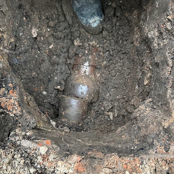 Excavated trench showing a collapsed underground clay drain pipe ready for expert structural repair by Drain Medics.