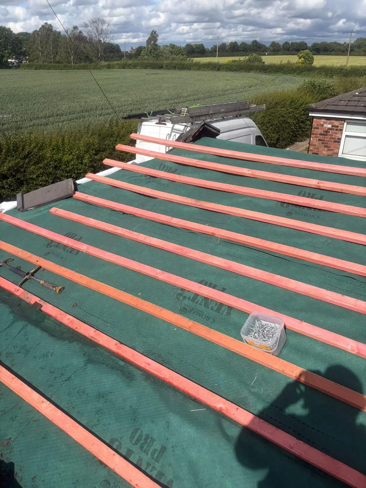 Roof replacement in progress showing the installation of green breathable membrane and timber roofing battens