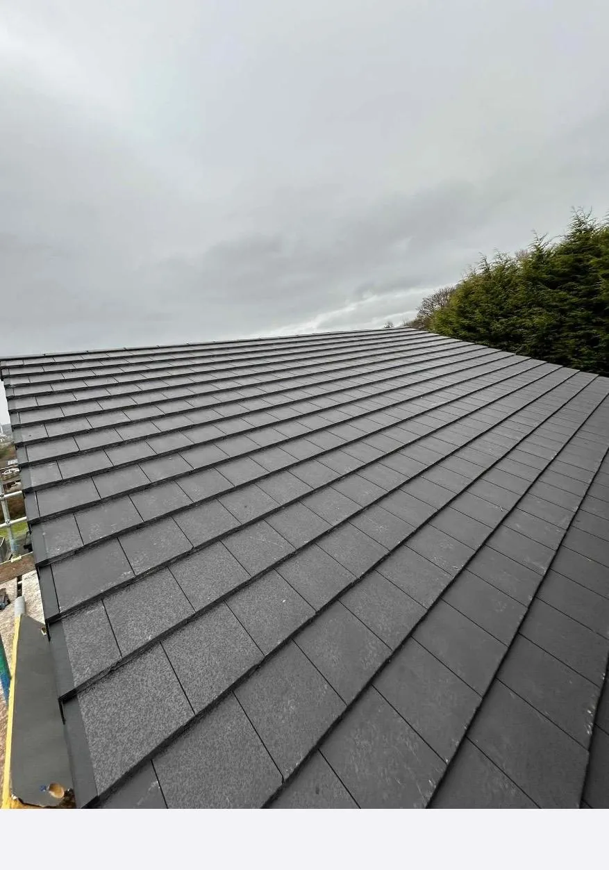 A professionally installed new roof with dark grey tiles and a dry fix verge system