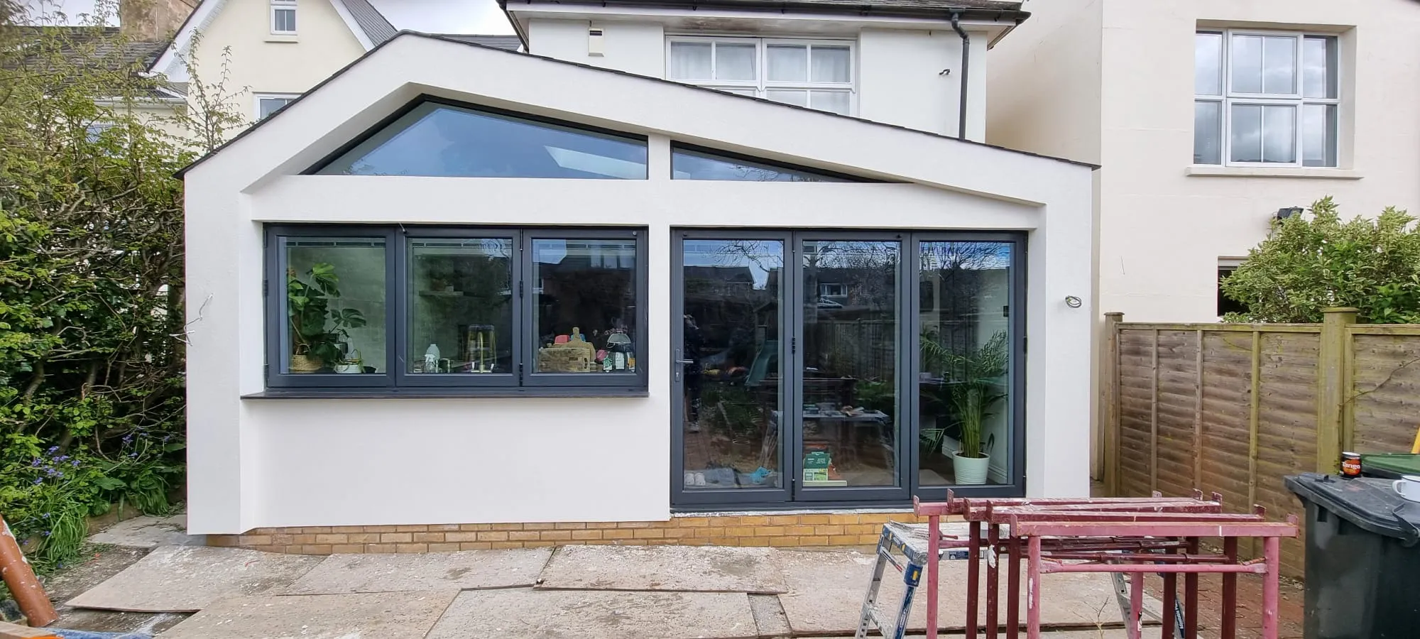A modern home extension with professional white external rendering and dark grey windows.
