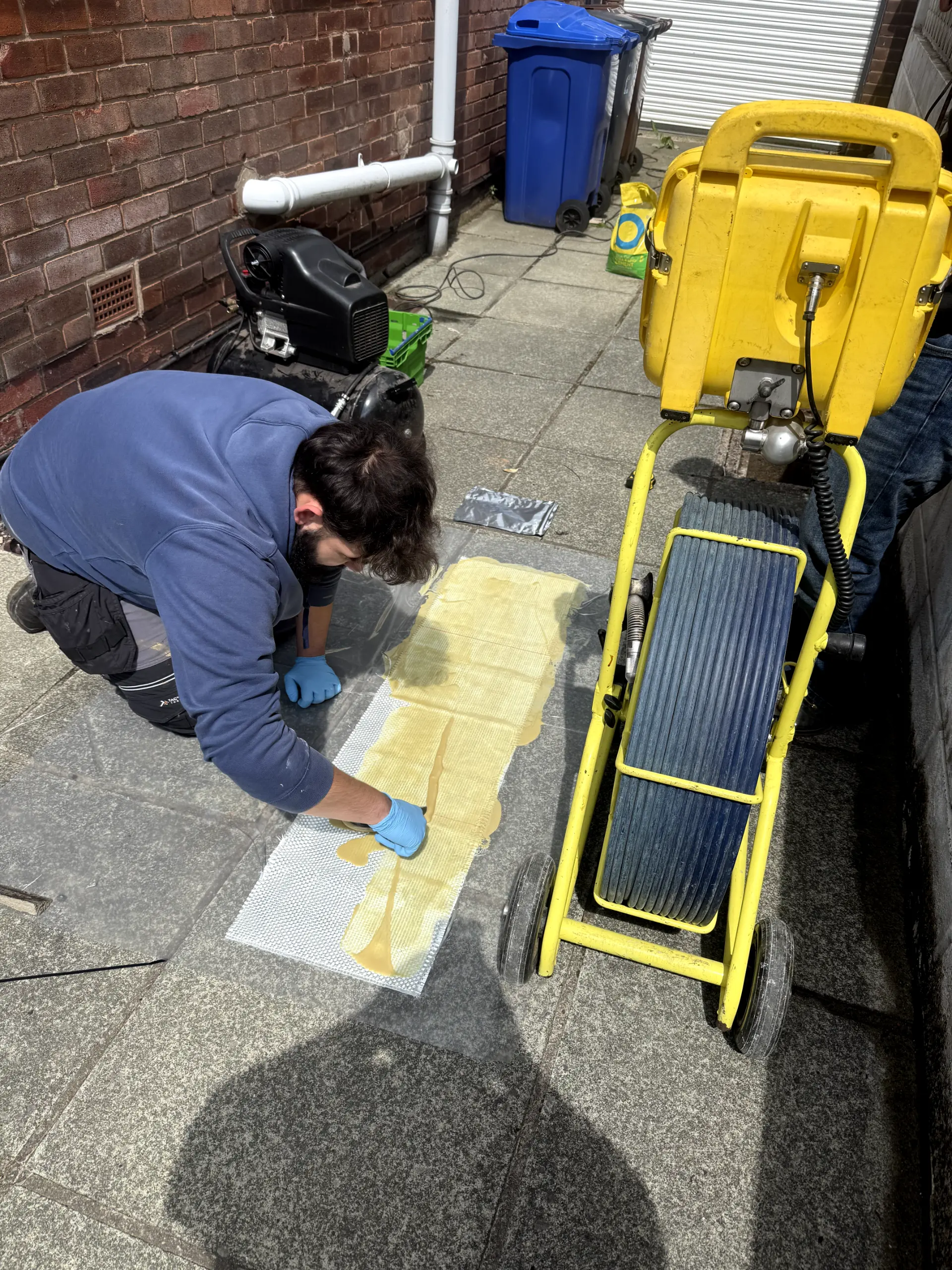 WGS Services engineer preparing a trenchless pipe lining patch for no-dig drain repair in Darwen