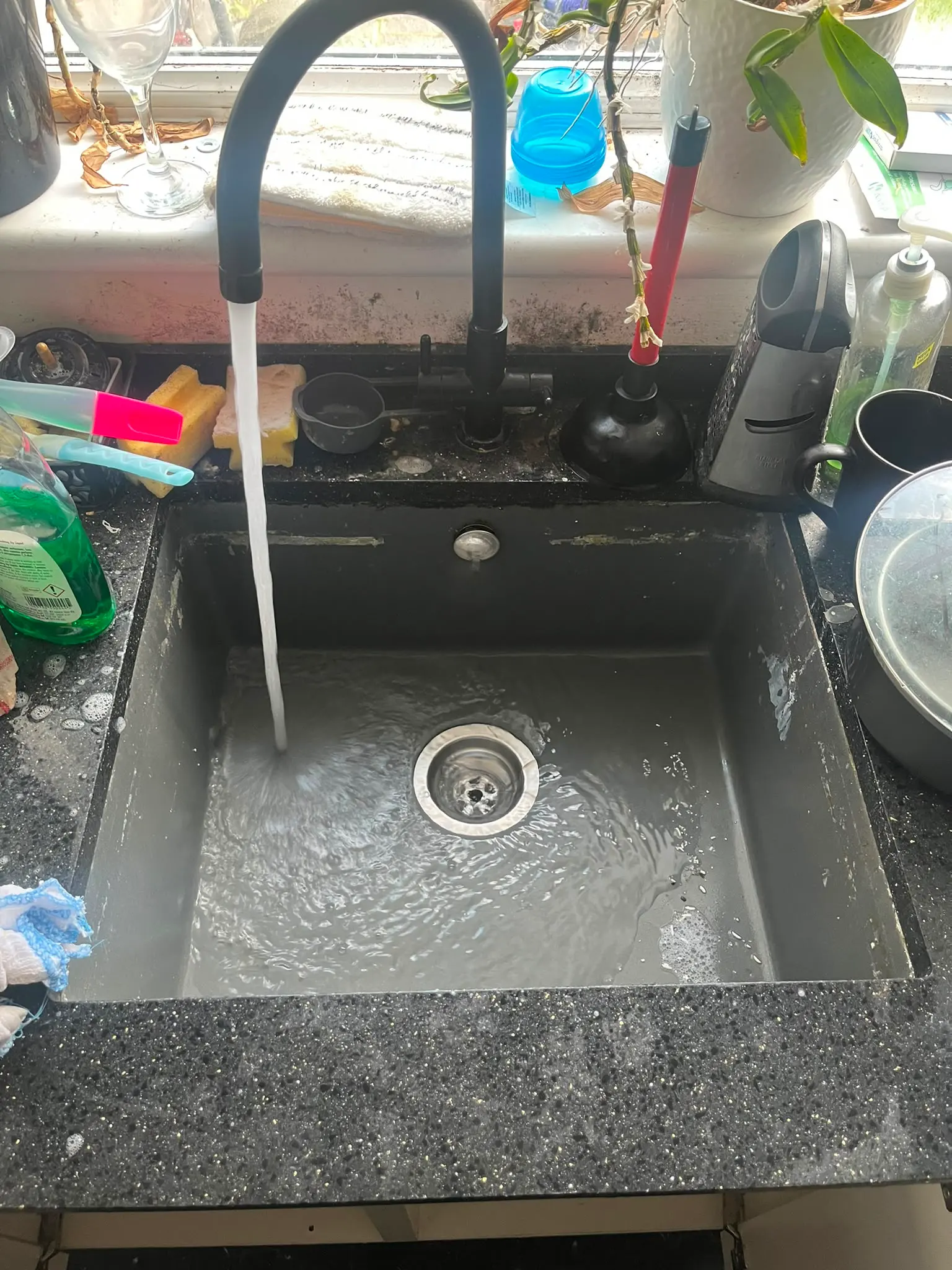A blocked kitchen sink with standing water requiring drain unblocking services