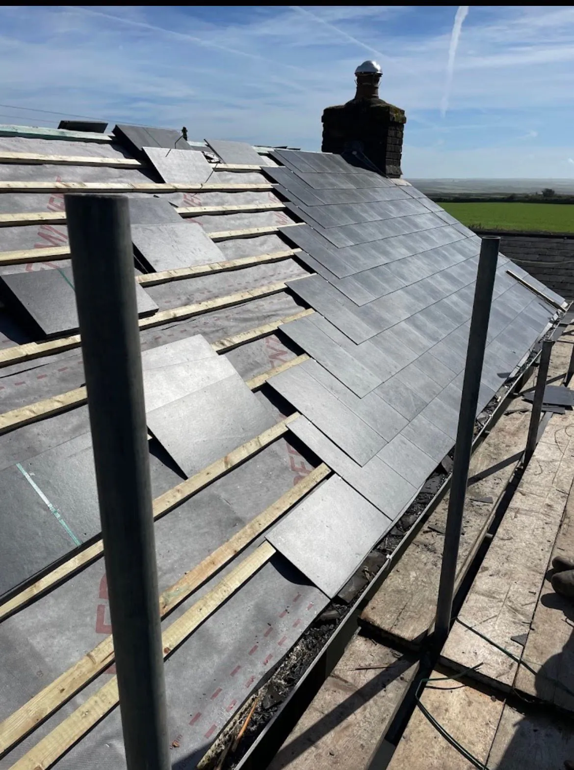 Slate roof replacement in progress with new battens and membrane