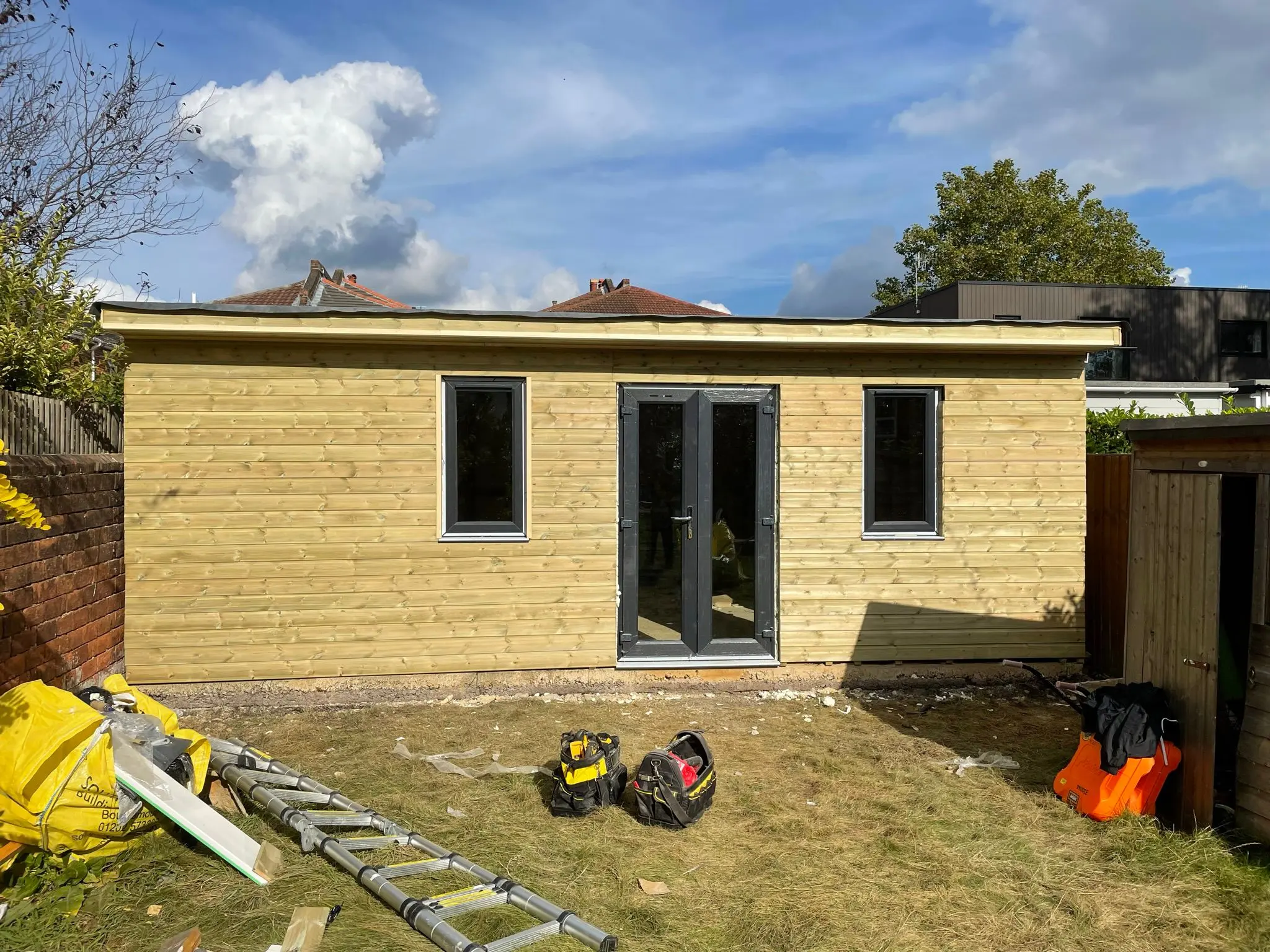 Bespoke timber garden room and home office under construction in a residential garden by Aline Construction.