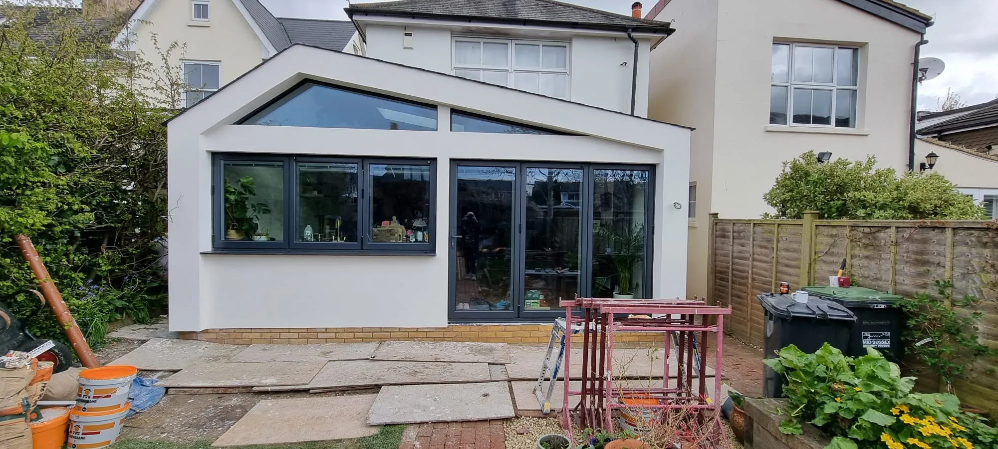 A modern home extension in Sussex featuring high-quality white external rendering and anthracite grey windows.