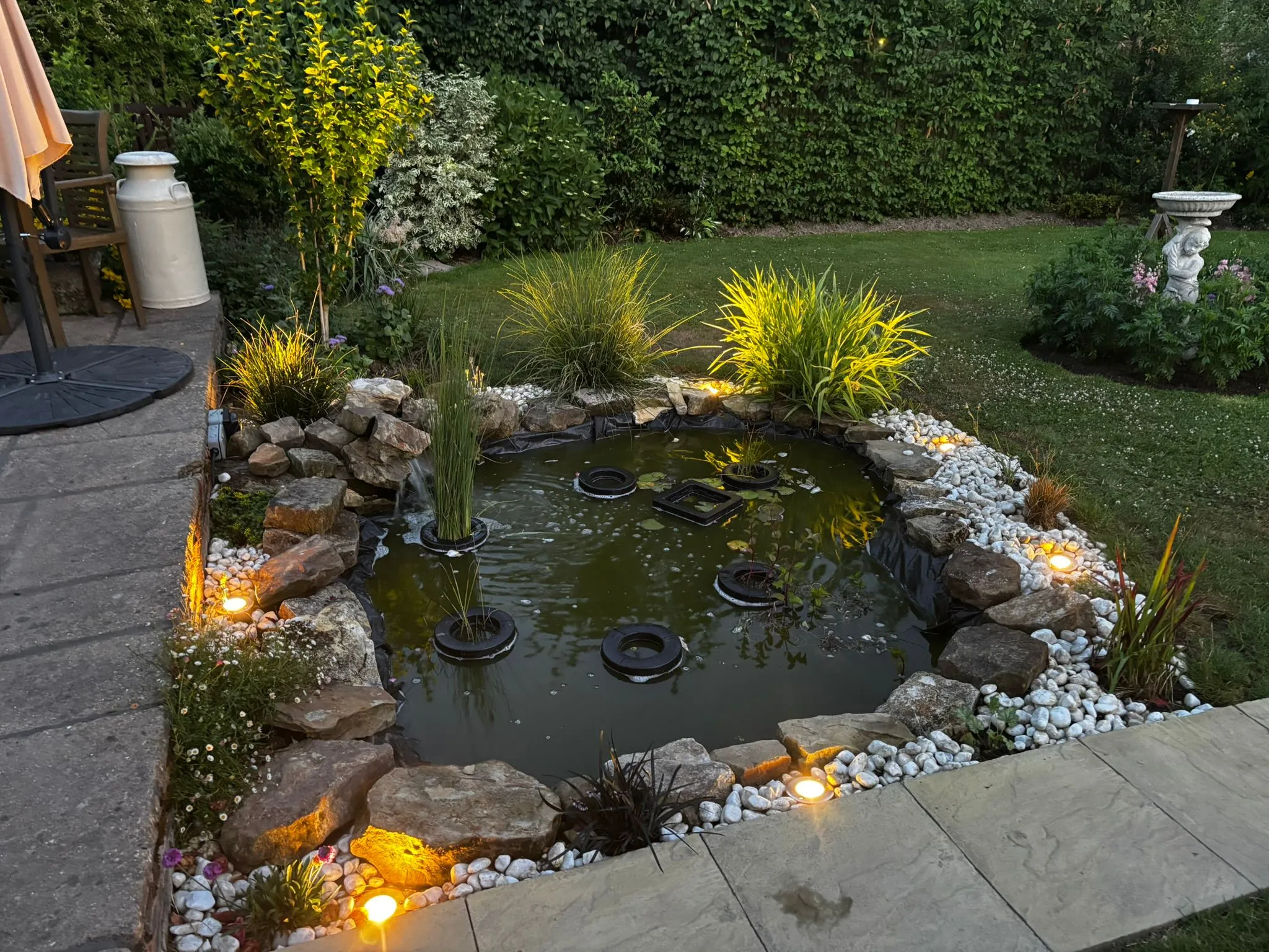 Outdoor garden lighting installation around a pond by an electrician in Sussex.