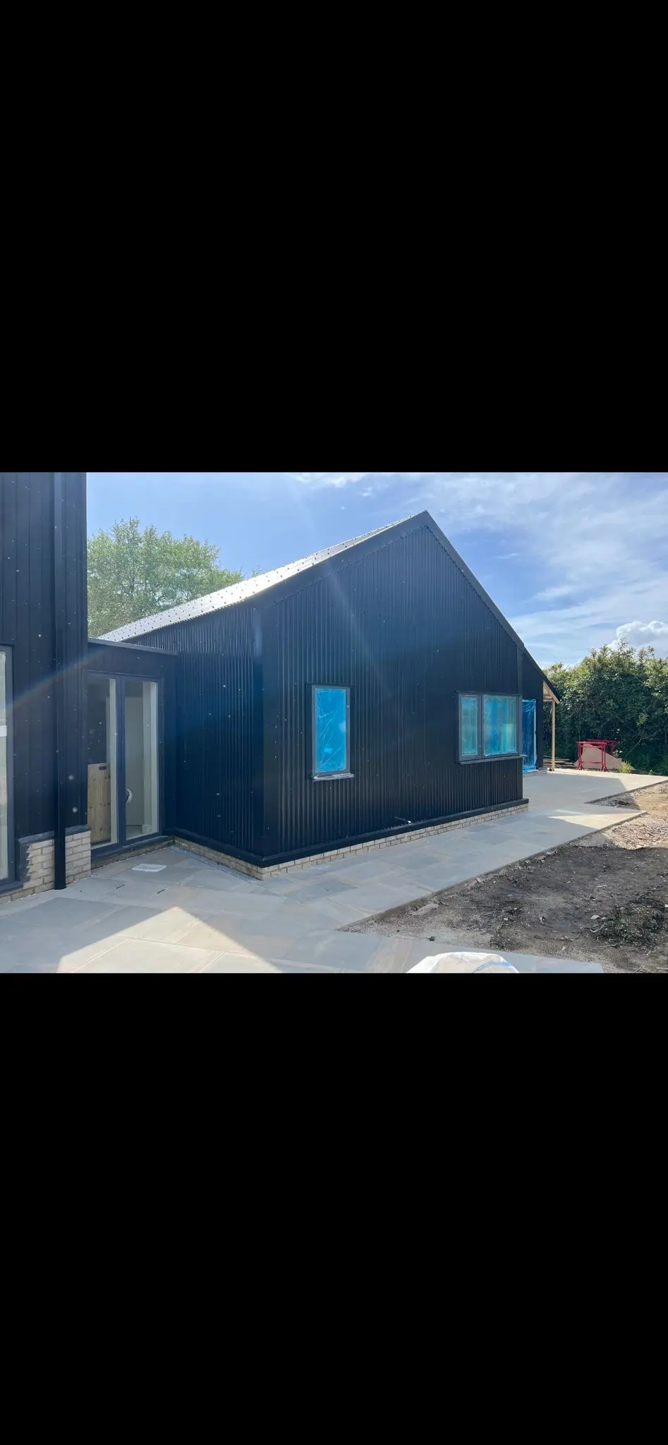 Modern commercial building finished with black corrugated weather-resistant cladding installed by ER3 Group LTD