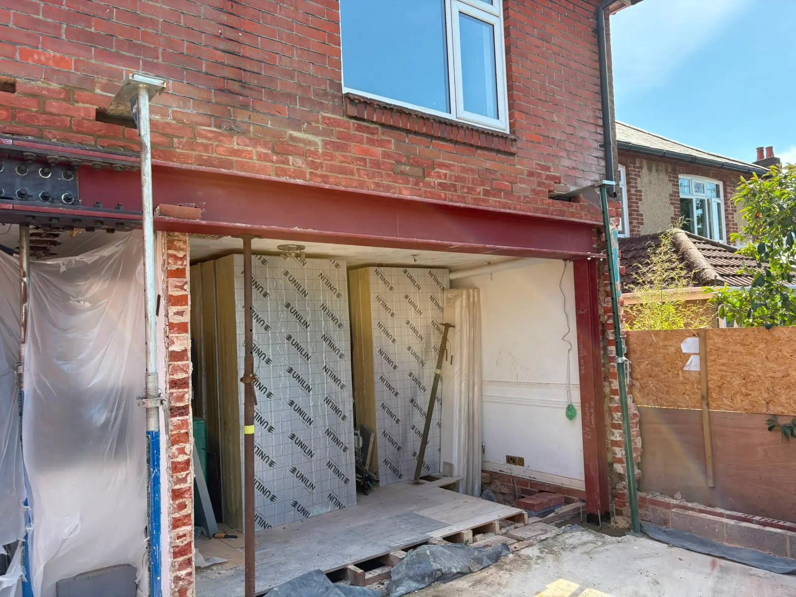 Structural RSJ steel beam installation supported by Acrow props for an open-plan home extension