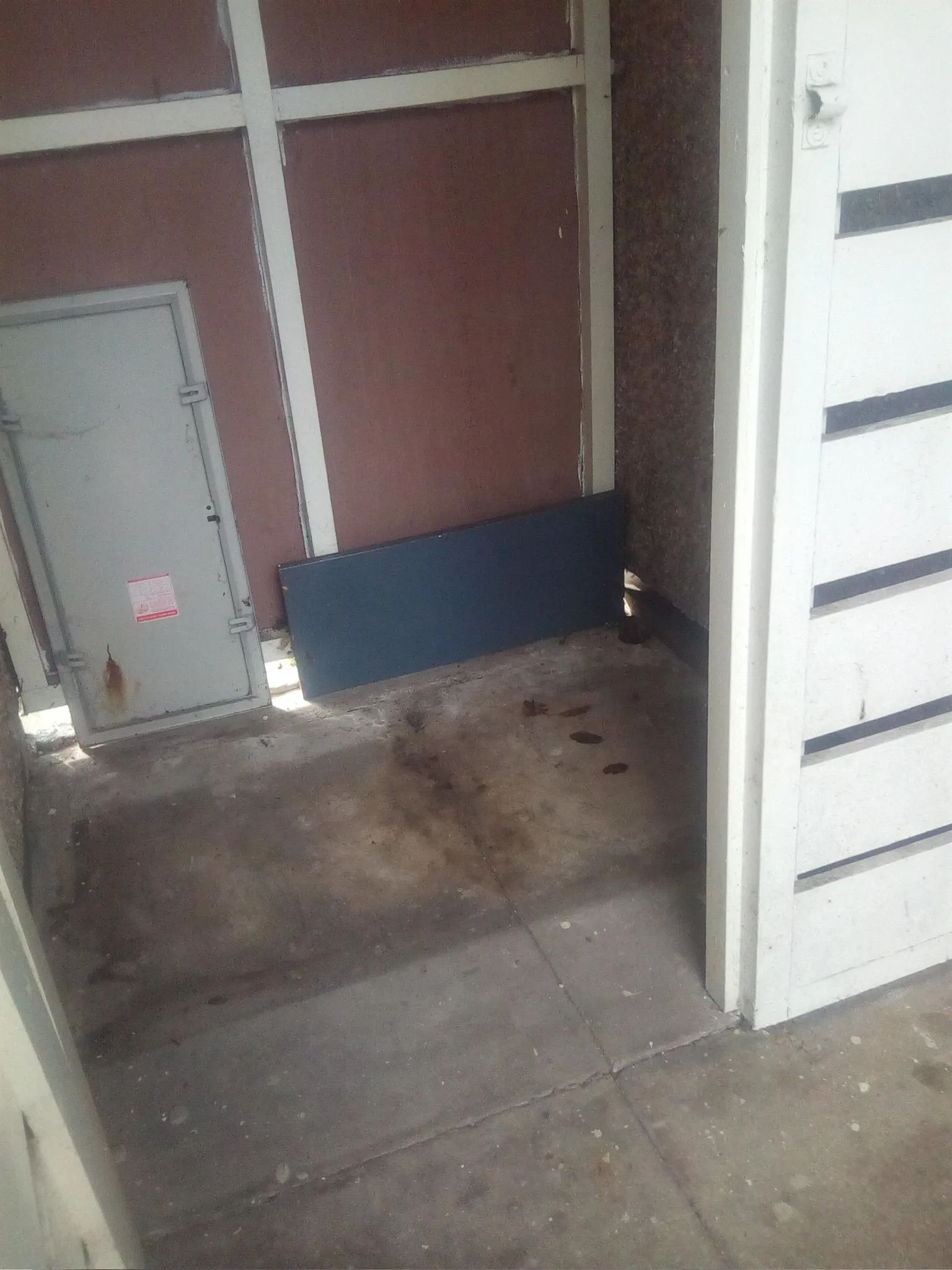 Internal utility space with an access hatch and stained concrete floor