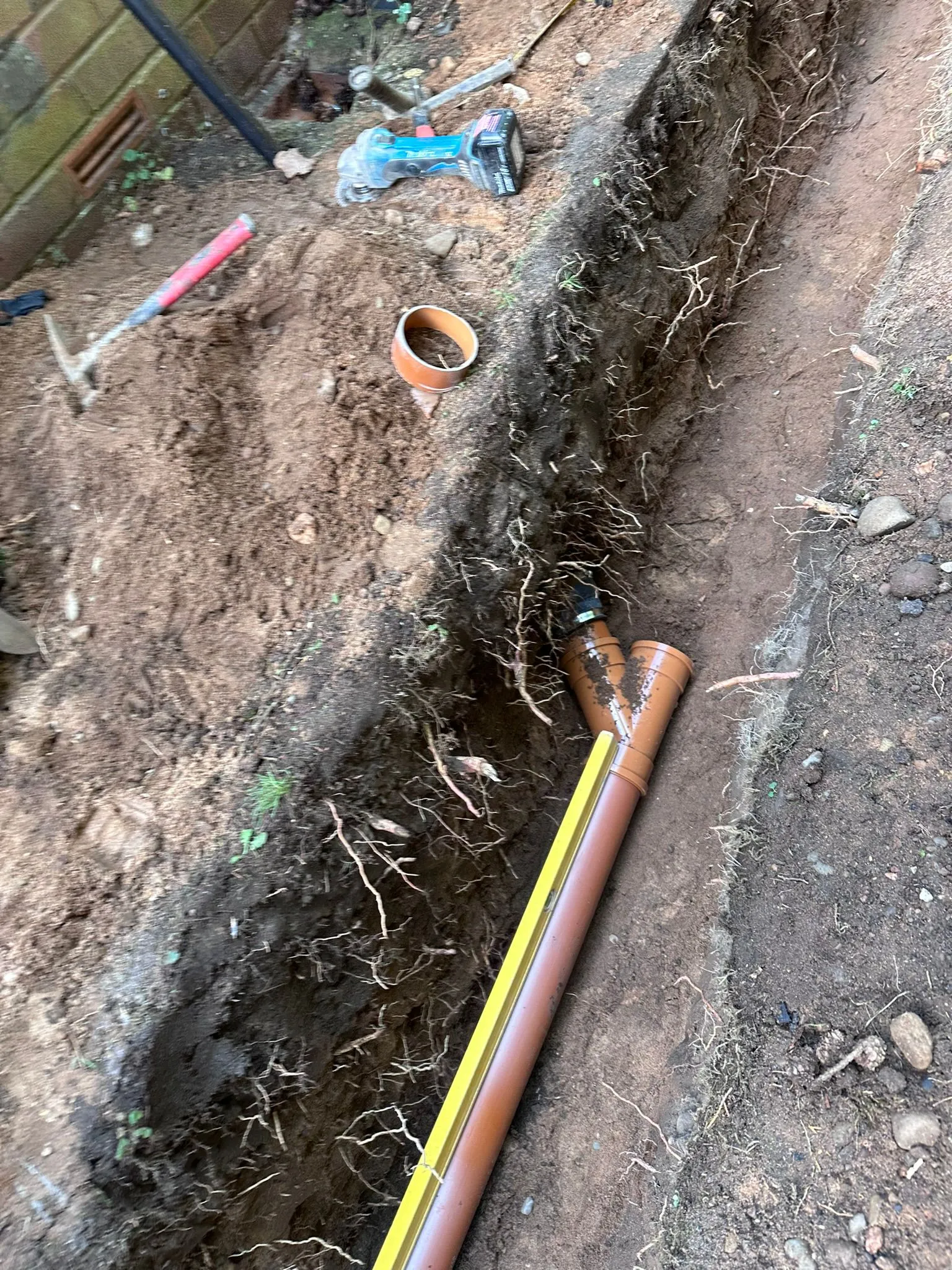 Drainage pipe installation in a trench for drain repair services in Macclesfield.