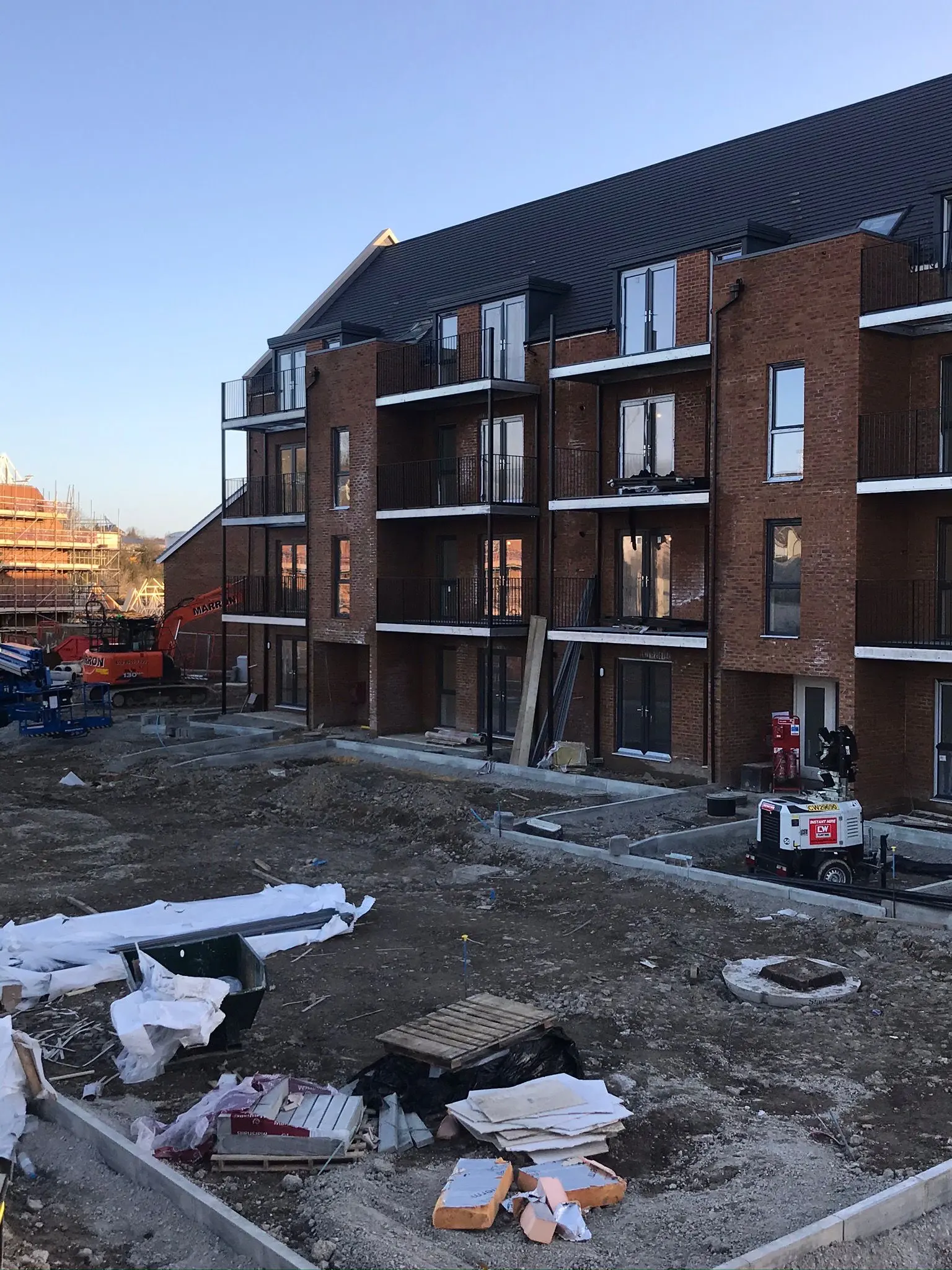 Ongoing commercial groundworks, site preparation, and concrete footings at a new building development construction site.