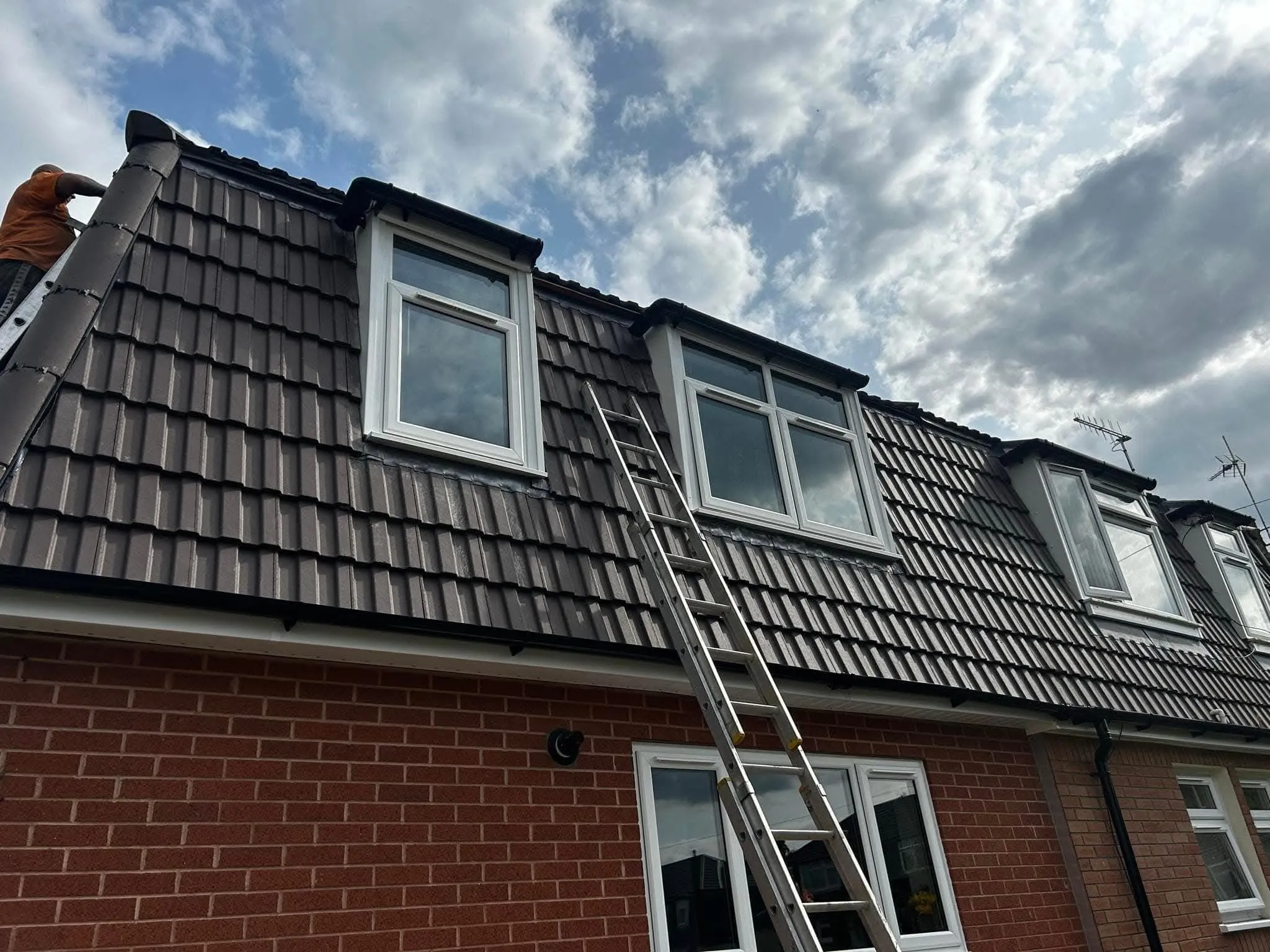 Expert roof repairs and maintenance on a domestic property with tiled dormer windows.