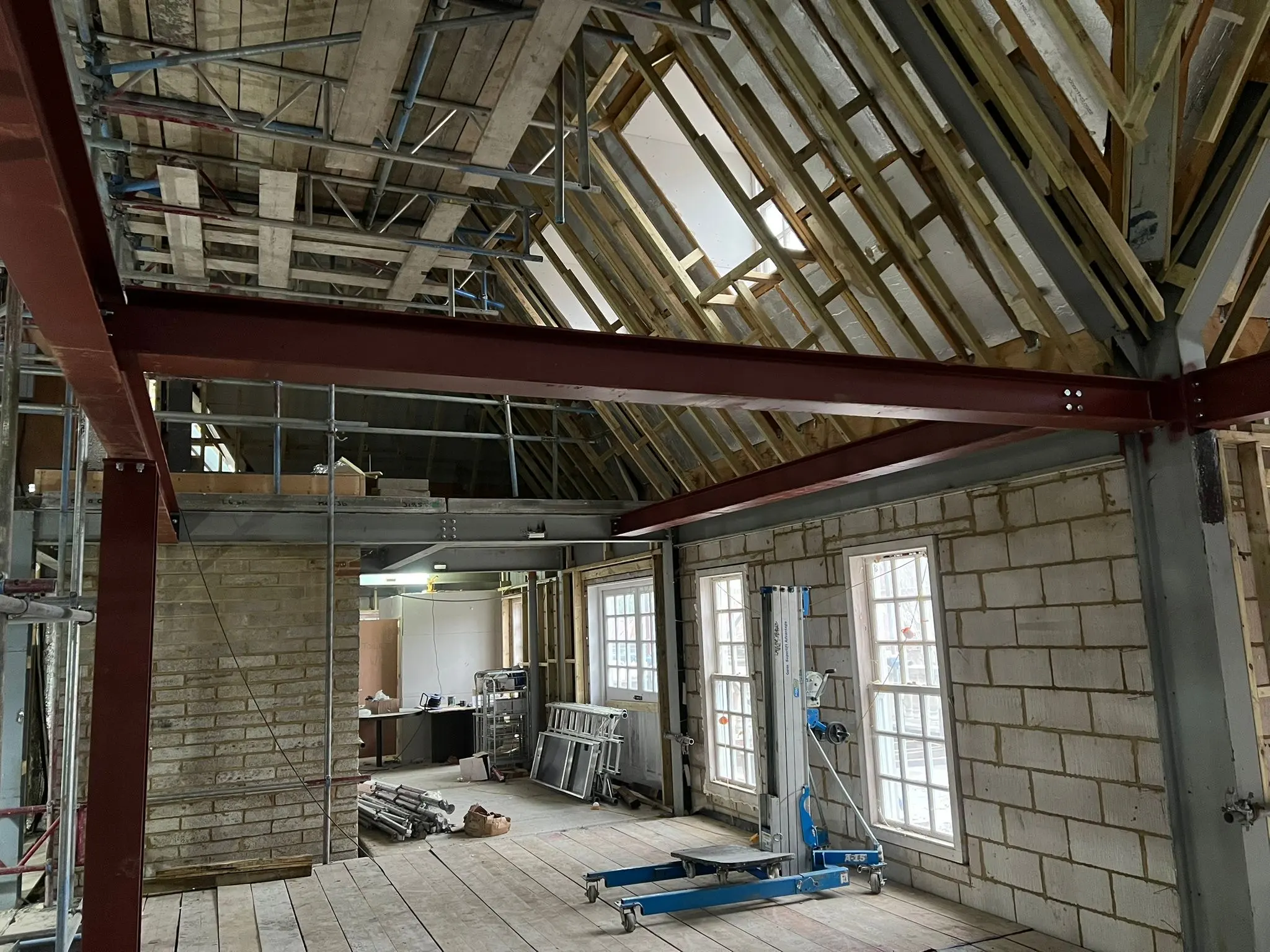 Structural steel frame erection and timber roof construction in progress