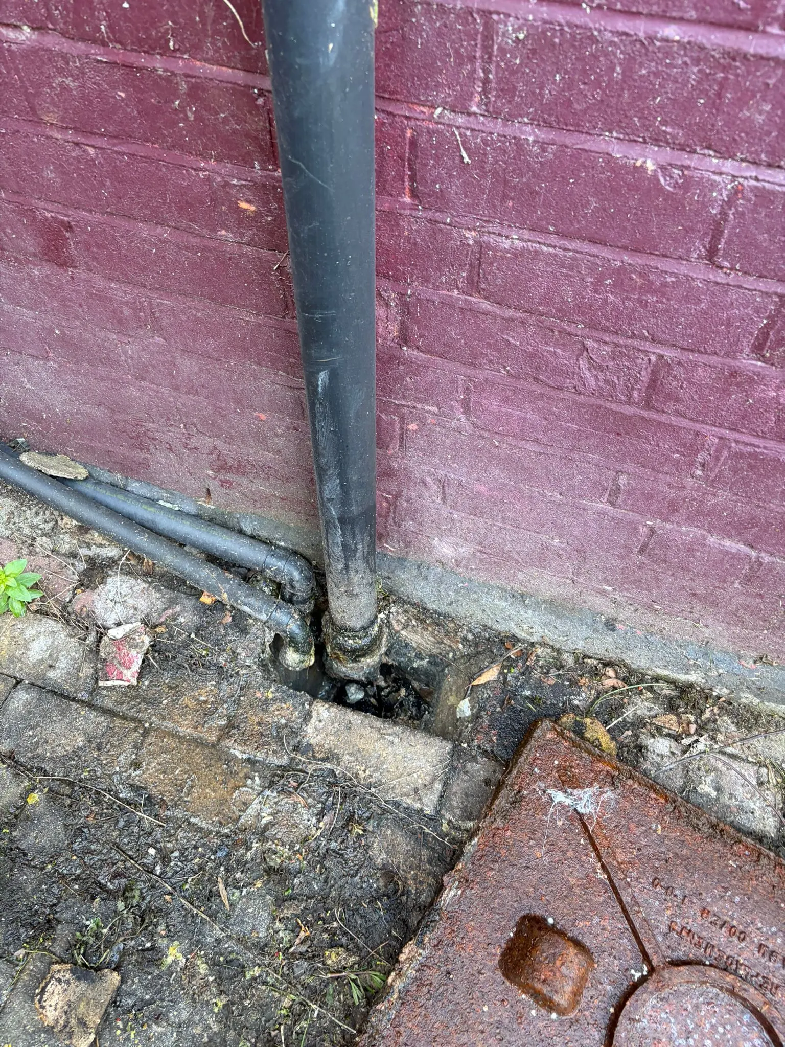 Blocked outside drain and manhole cover in Slough requiring emergency unblocking service.
