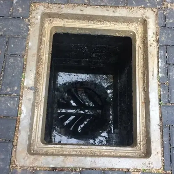 Open drain inspection chamber in block paving ready for a CCTV drain survey or emergency drain unblocking by Drain Medics