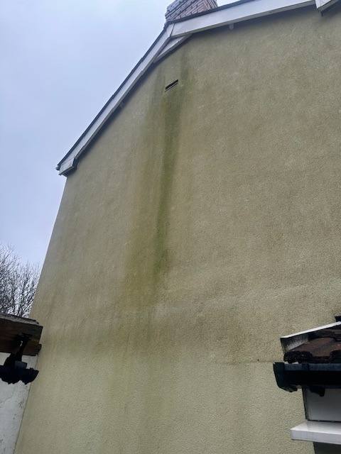 Weathered and stained exterior render on a house gable end requiring professional rendering or insulation services