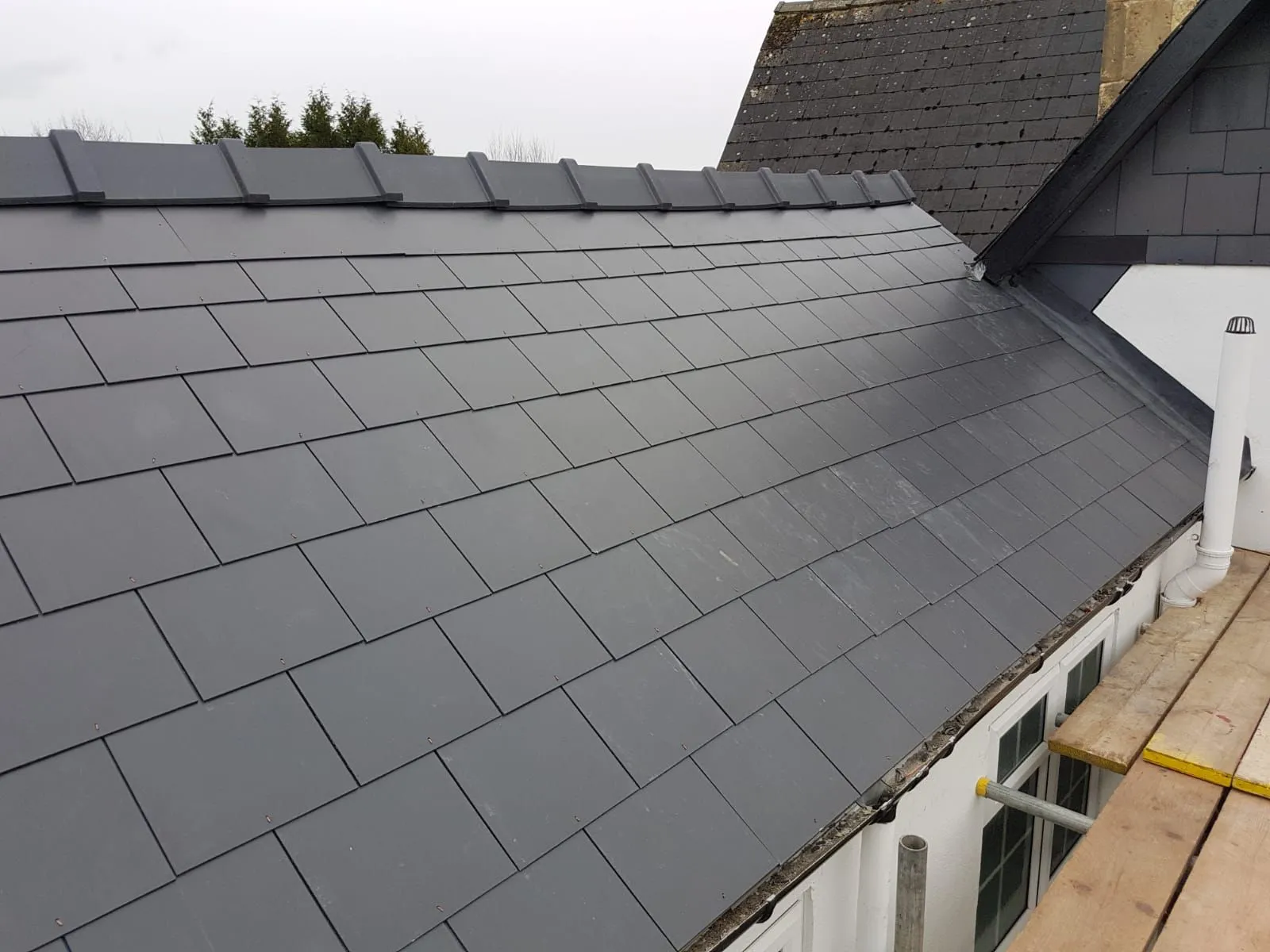 A newly installed grey tiled roof with a dry ridge system in Gloucestershire.