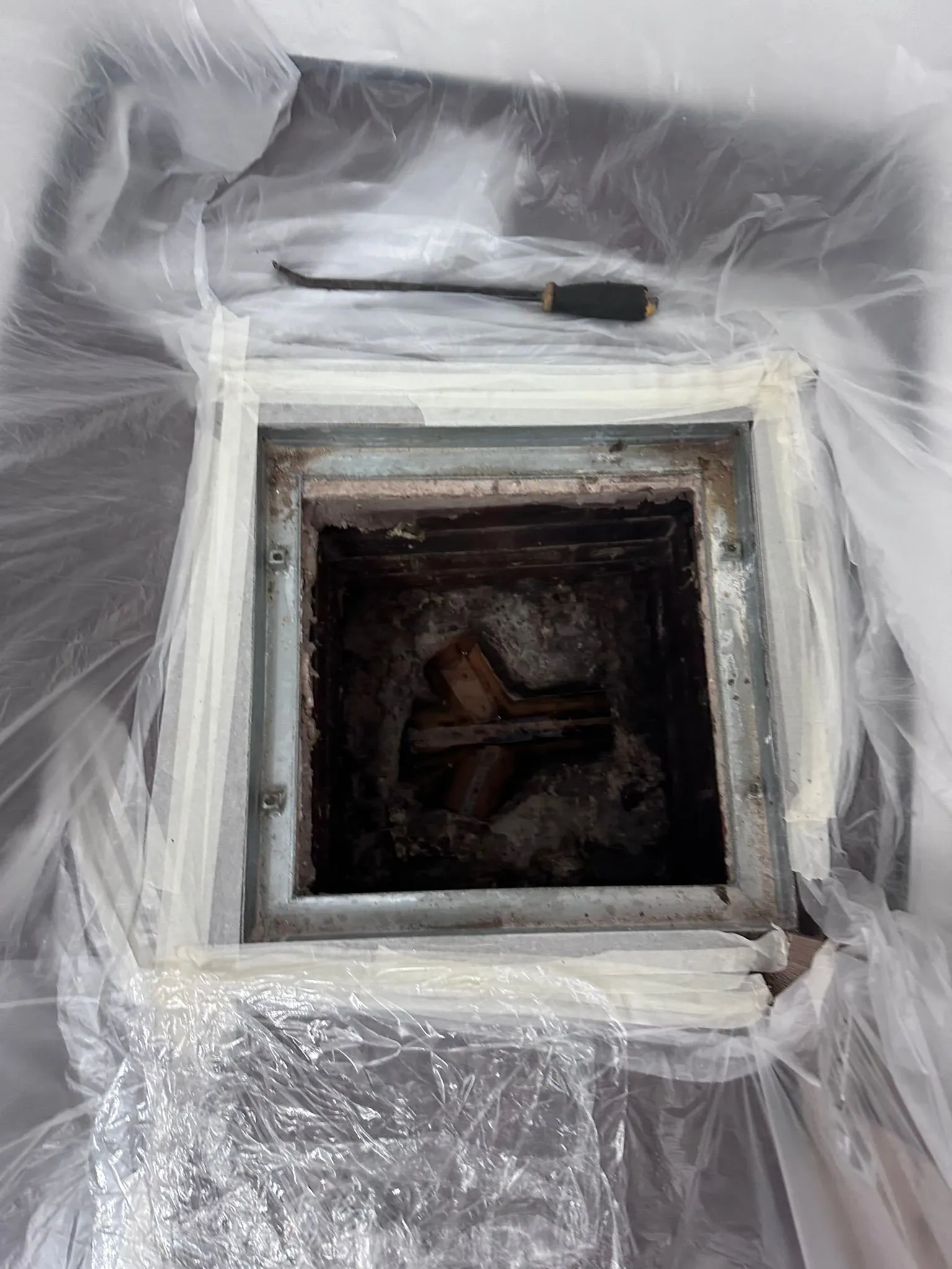 Internal drainage inspection chamber open for maintenance with protective floor covering.