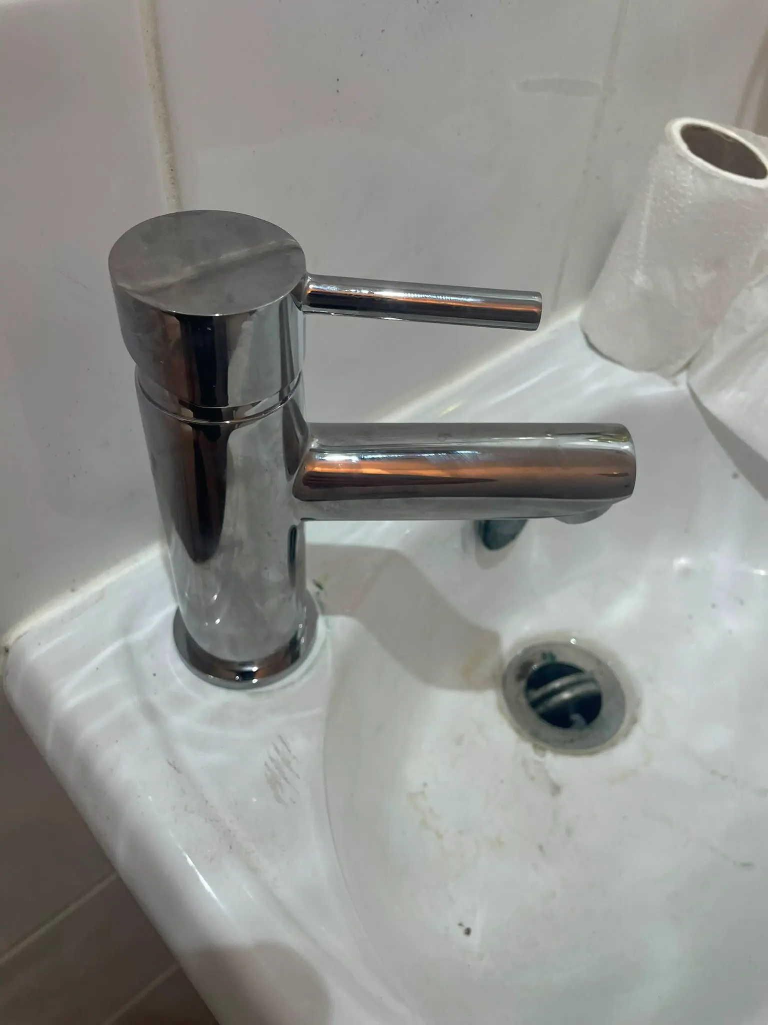 A close-up view of a chrome mixer tap on a white bathroom sink