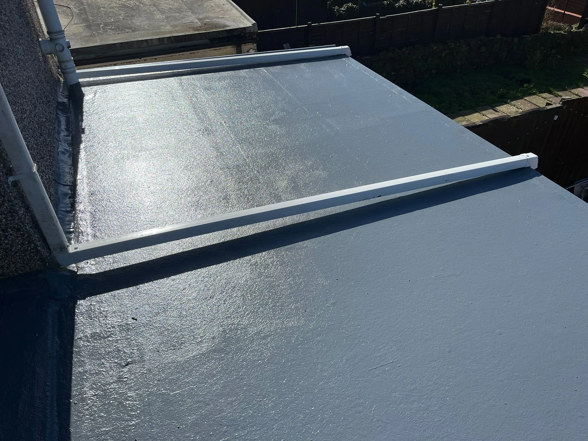 A professional flat roof installation with a grey waterproof finish in Gloucestershire.