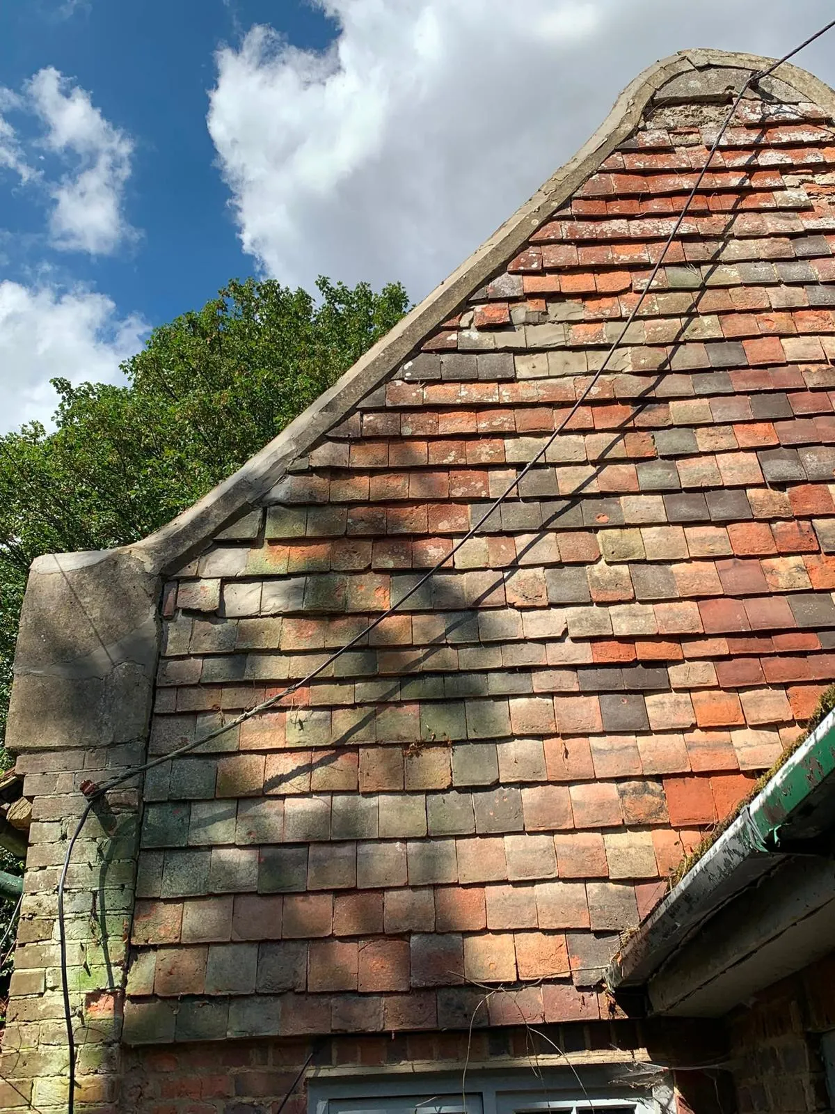 Traditional Kent peg clay tile hanging and pitched roof repairs on a heritage building