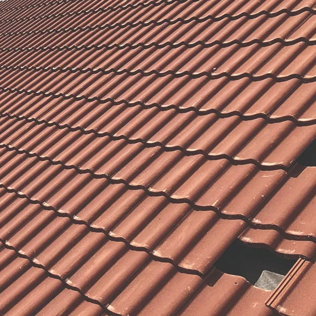 A tiled roof with missing red tiles, showing an area that requires repair or replacement.