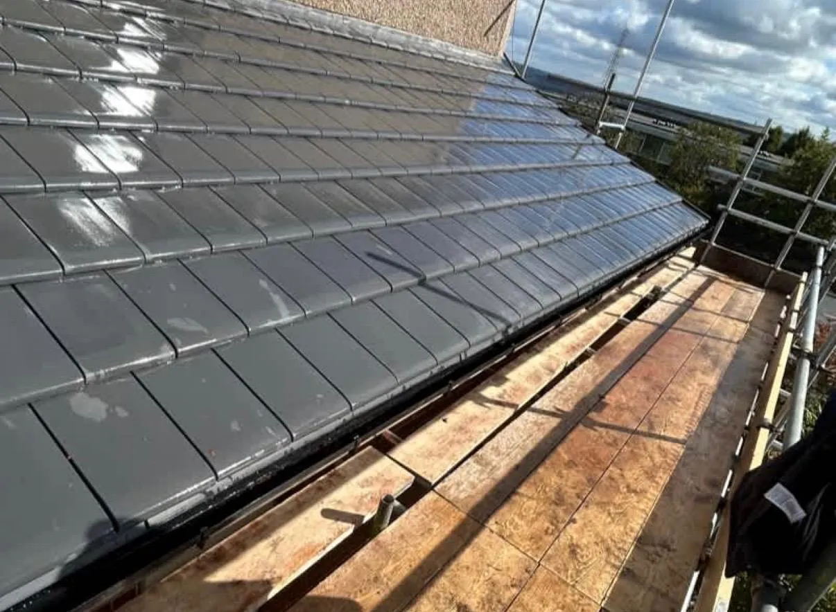 A professional installation of modern grey roof tiles on a residential property by Tyler’s Roofing Services.