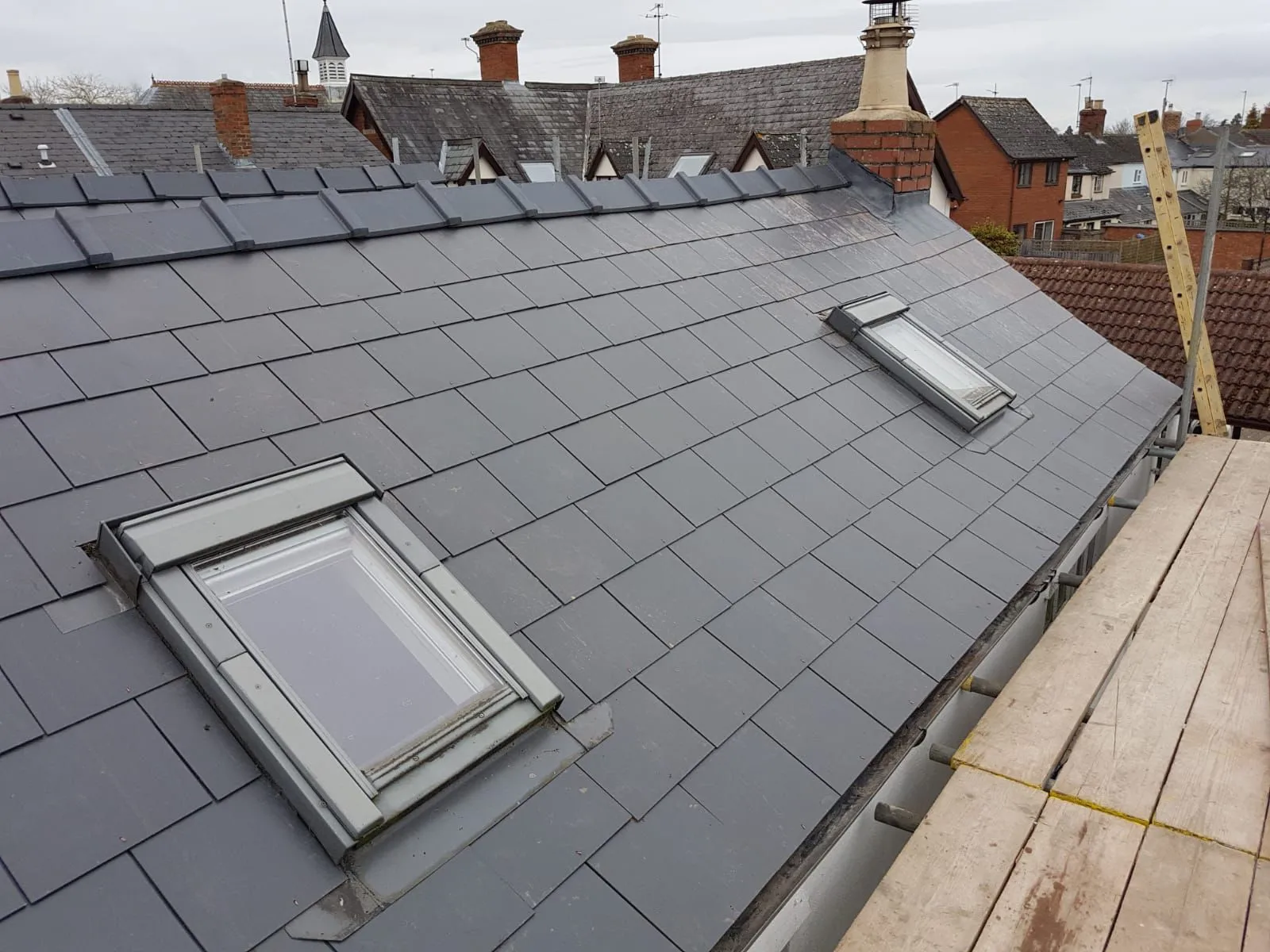 Professional pitched roof installation with grey tiles and roof windows in Gloucestershire