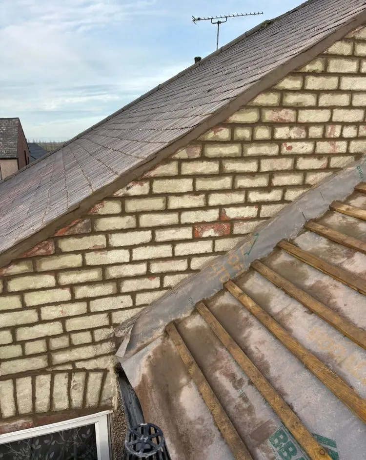 Professional new roof installation showing structural layers and repointed brickwork