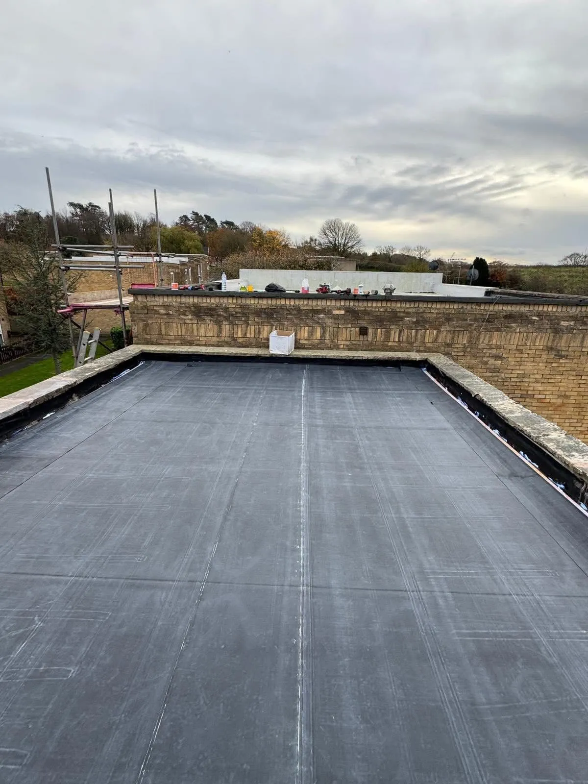 A completed flat roof installation in Otley, Leeds, showing the new membrane and parapet walls.