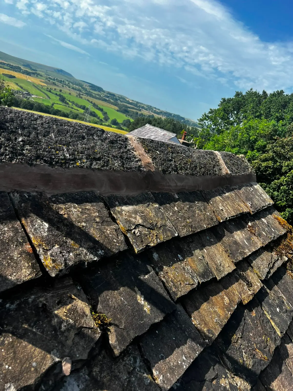 Freshly repointed ridge tiles on a pitched slate roof in Burnley