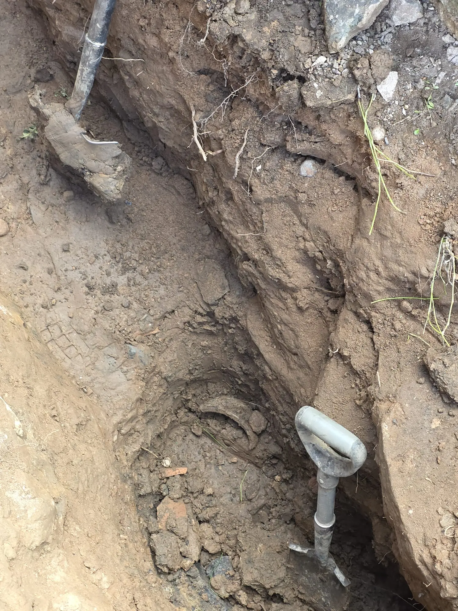Deep trench dug for drain excavation and replacement.
