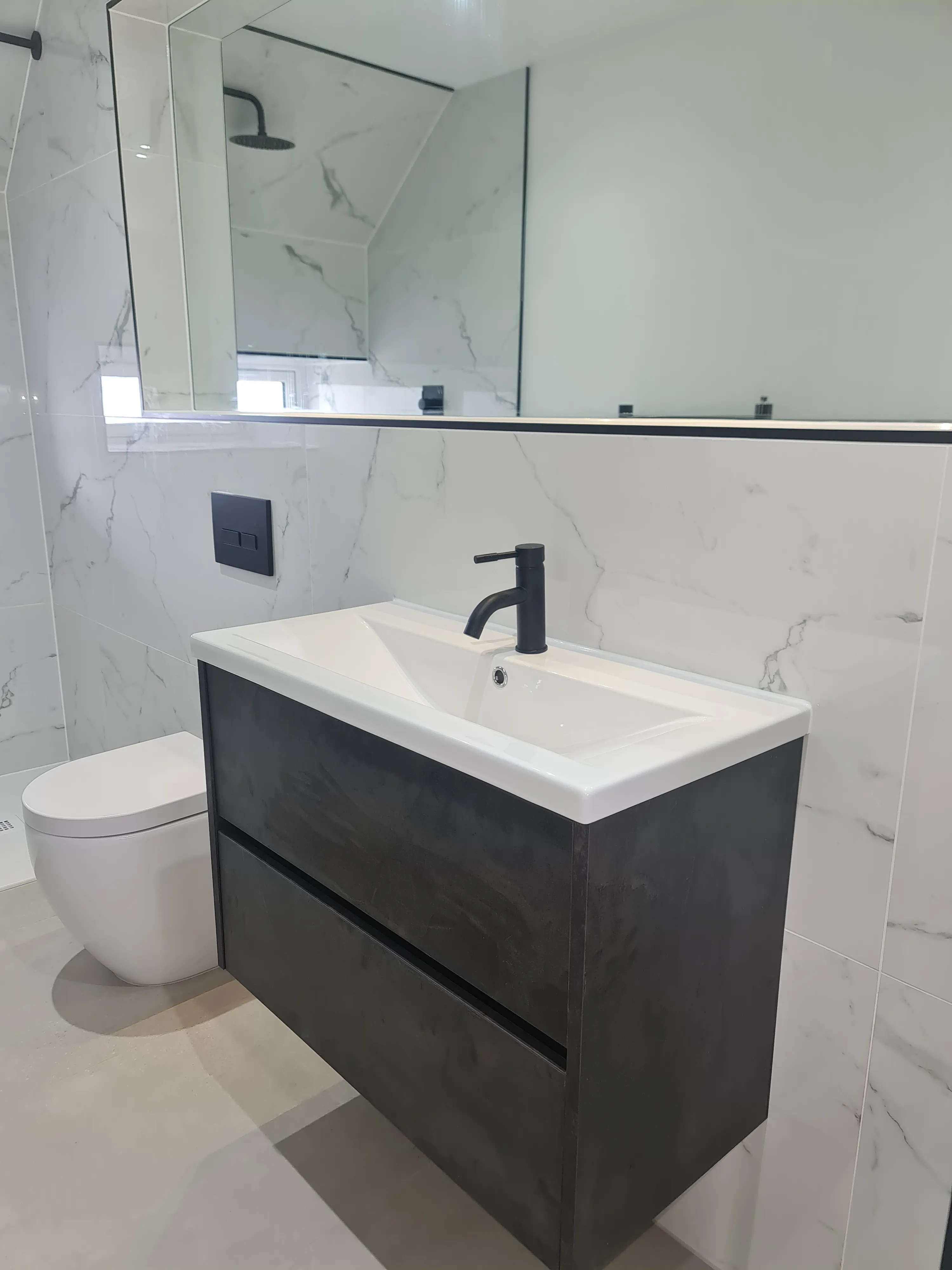 Luxury bespoke bathroom installation in Plymouth featuring marble tiling and matt black fixtures by Sands & Vossen.
