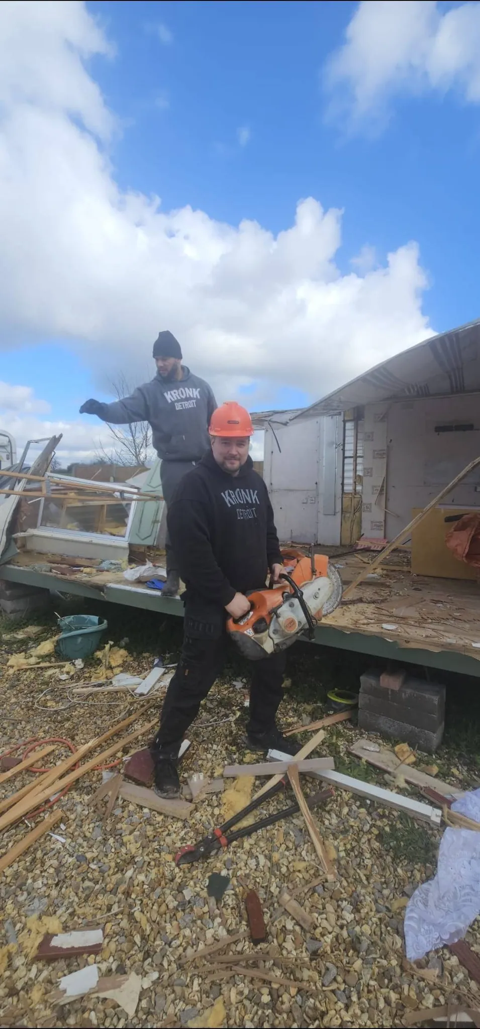 Operative with cutting equipment carrying out shed and outbuilding clearance and construction waste removal