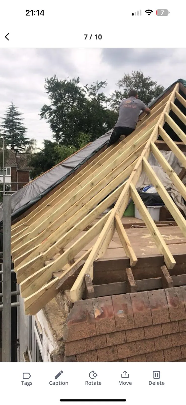 Roofer installing new roof timber frame with rafters and membrane.