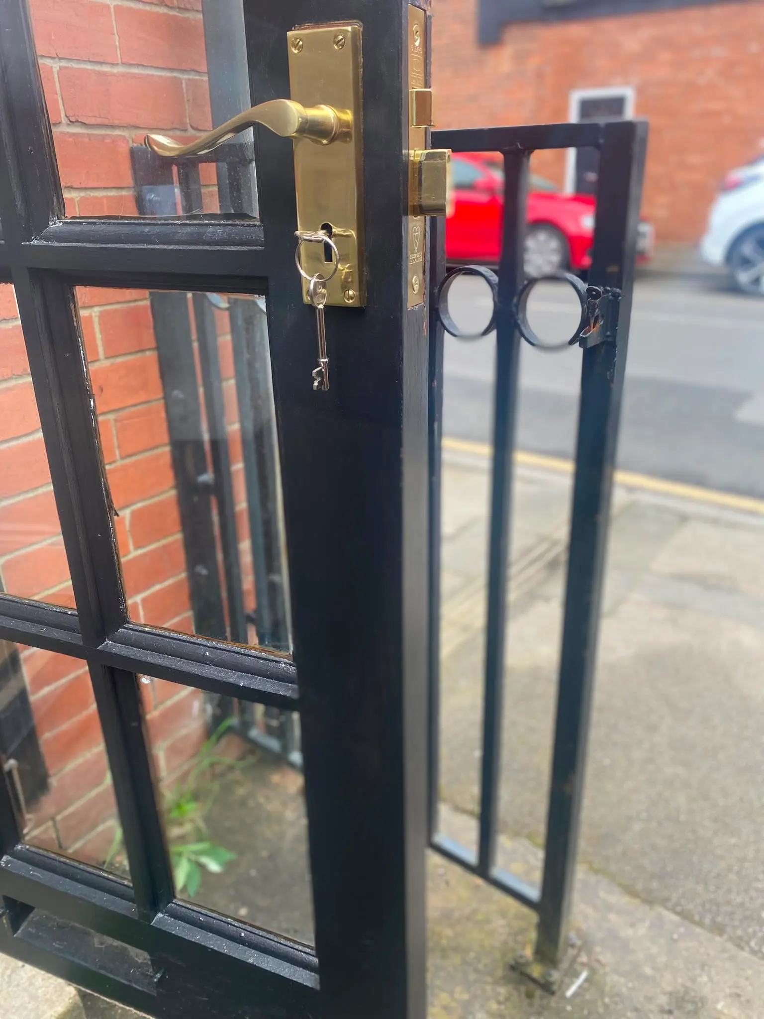 Newly fitted brass mortice lock and handle with key inserted on a black residential door by Locksafe York Ltd