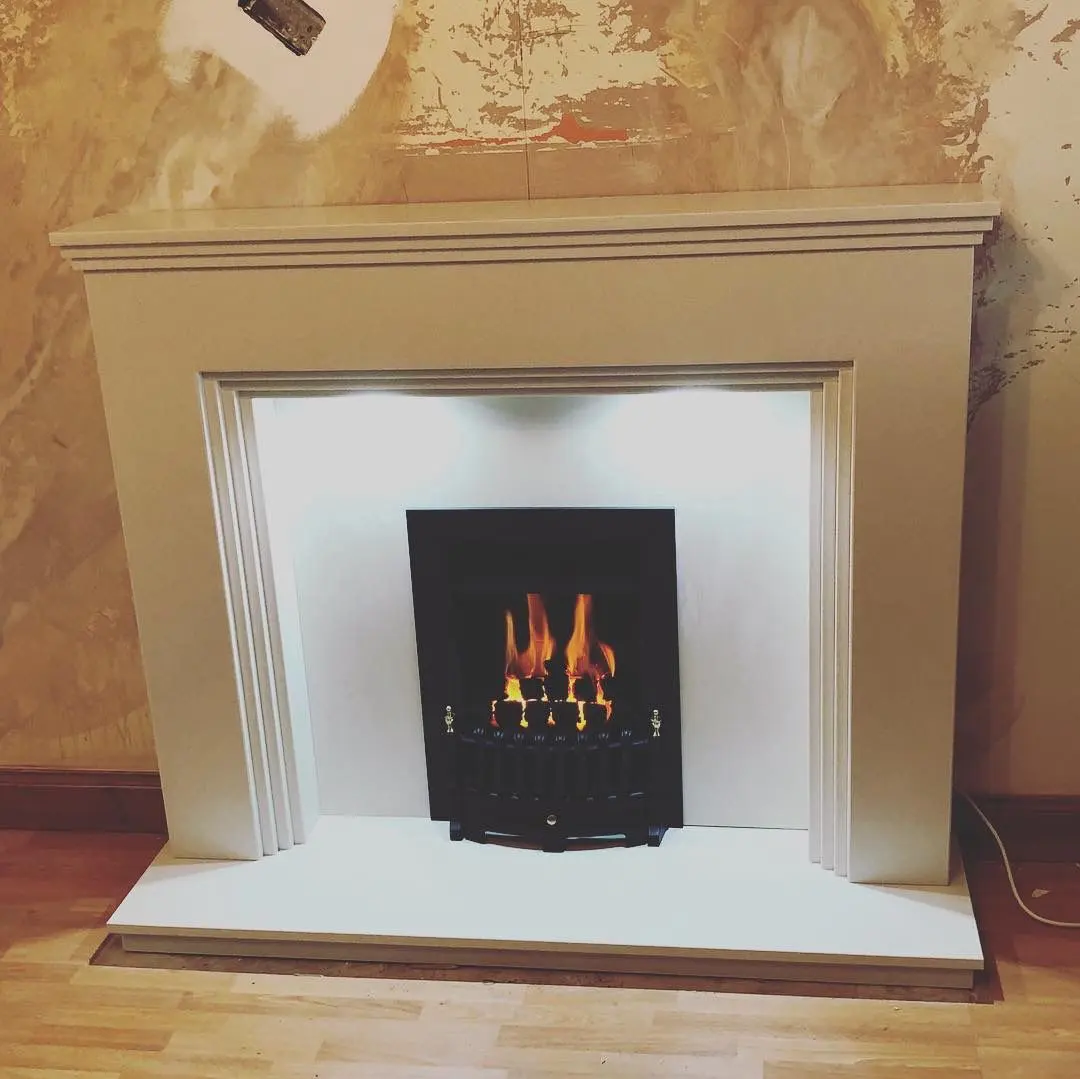 Modern gas fireplace with lit orange flames and a white stone-effect mantelpiece