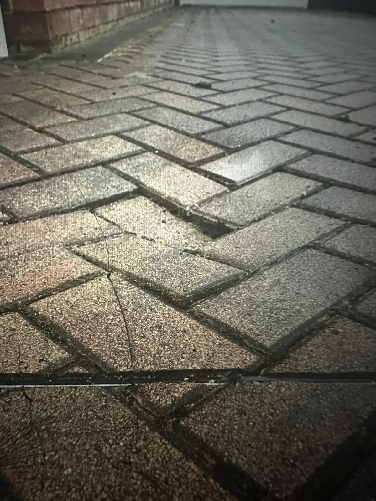 Sunken block paving on a driveway indicating potential drainage failure