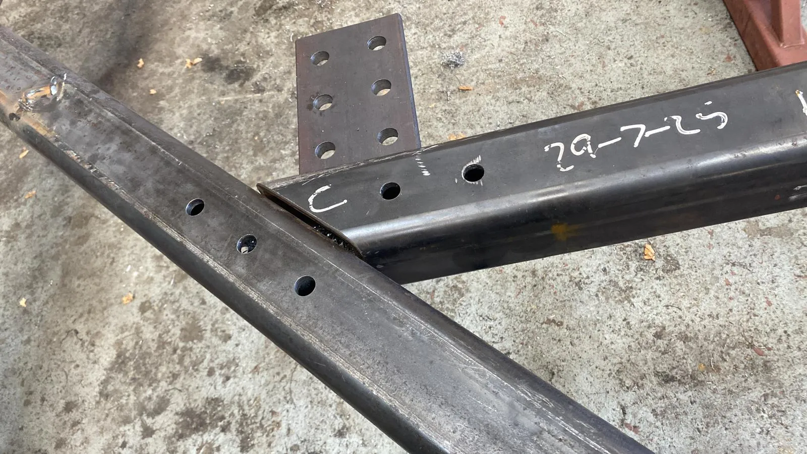 A close-up of fabricated structural steel components with precision-drilled holes for a construction project.