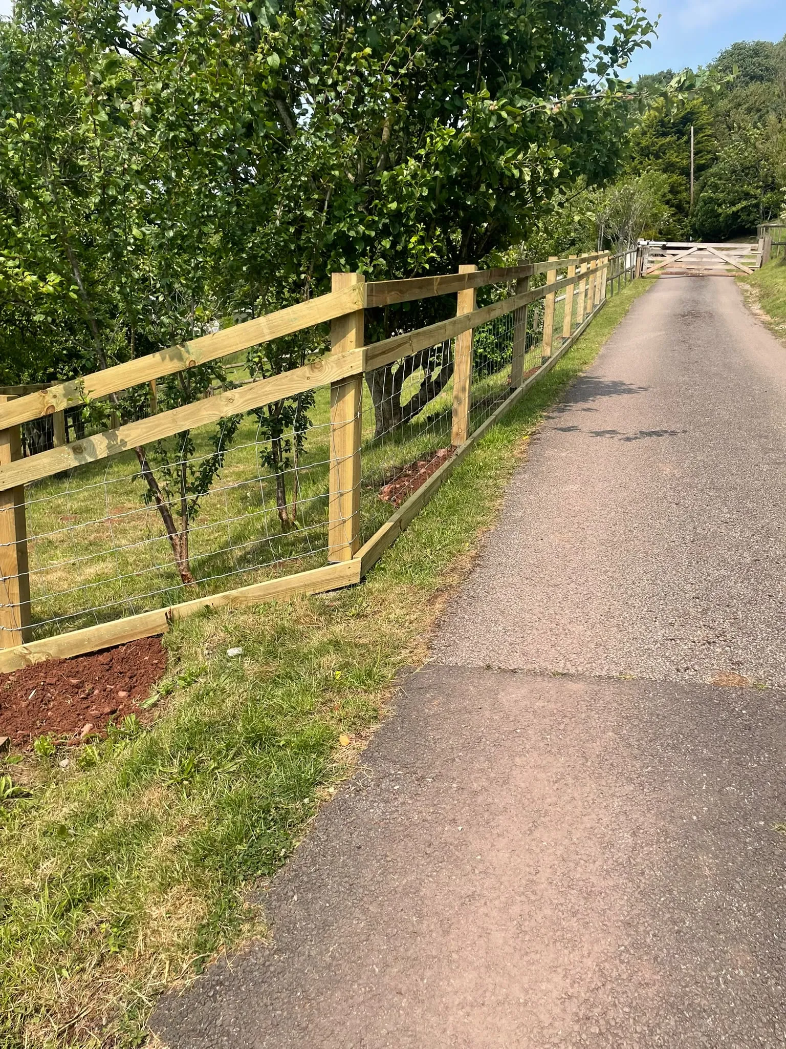Post and rail timber fencing installation along a rural driveway installed by JDP Outdoor Solutions