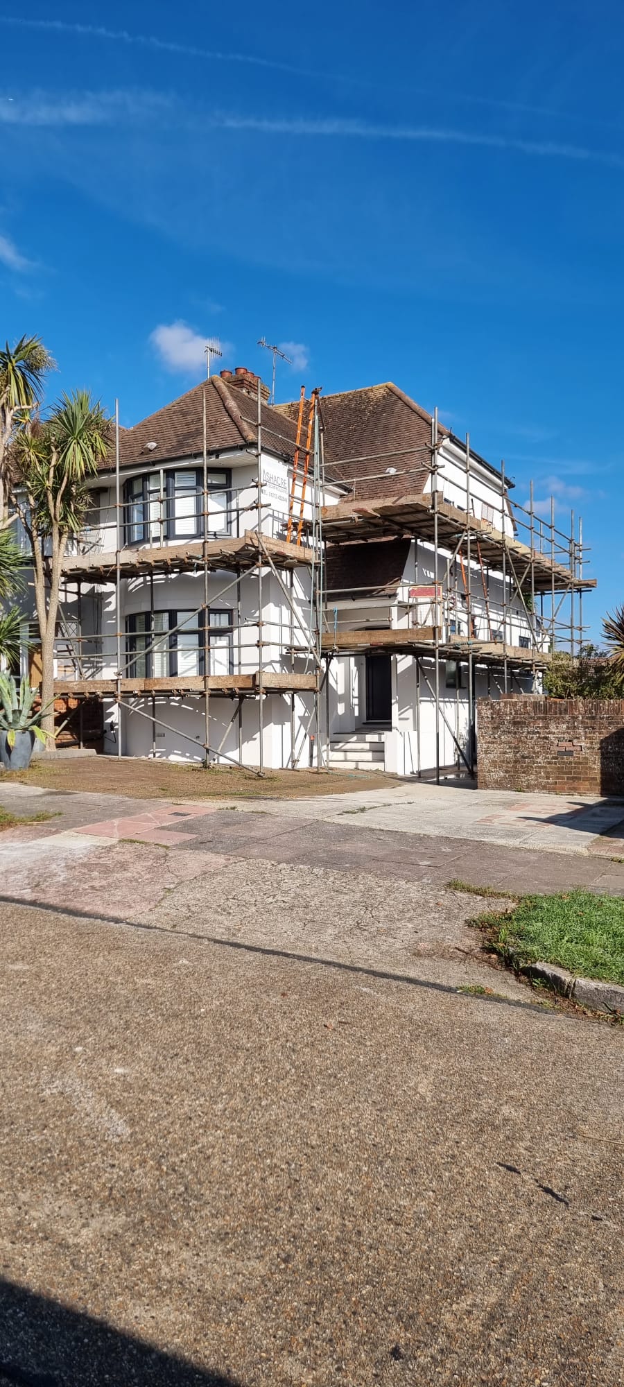 Professional external rendering project with scaffolding on a white house in Sussex.
