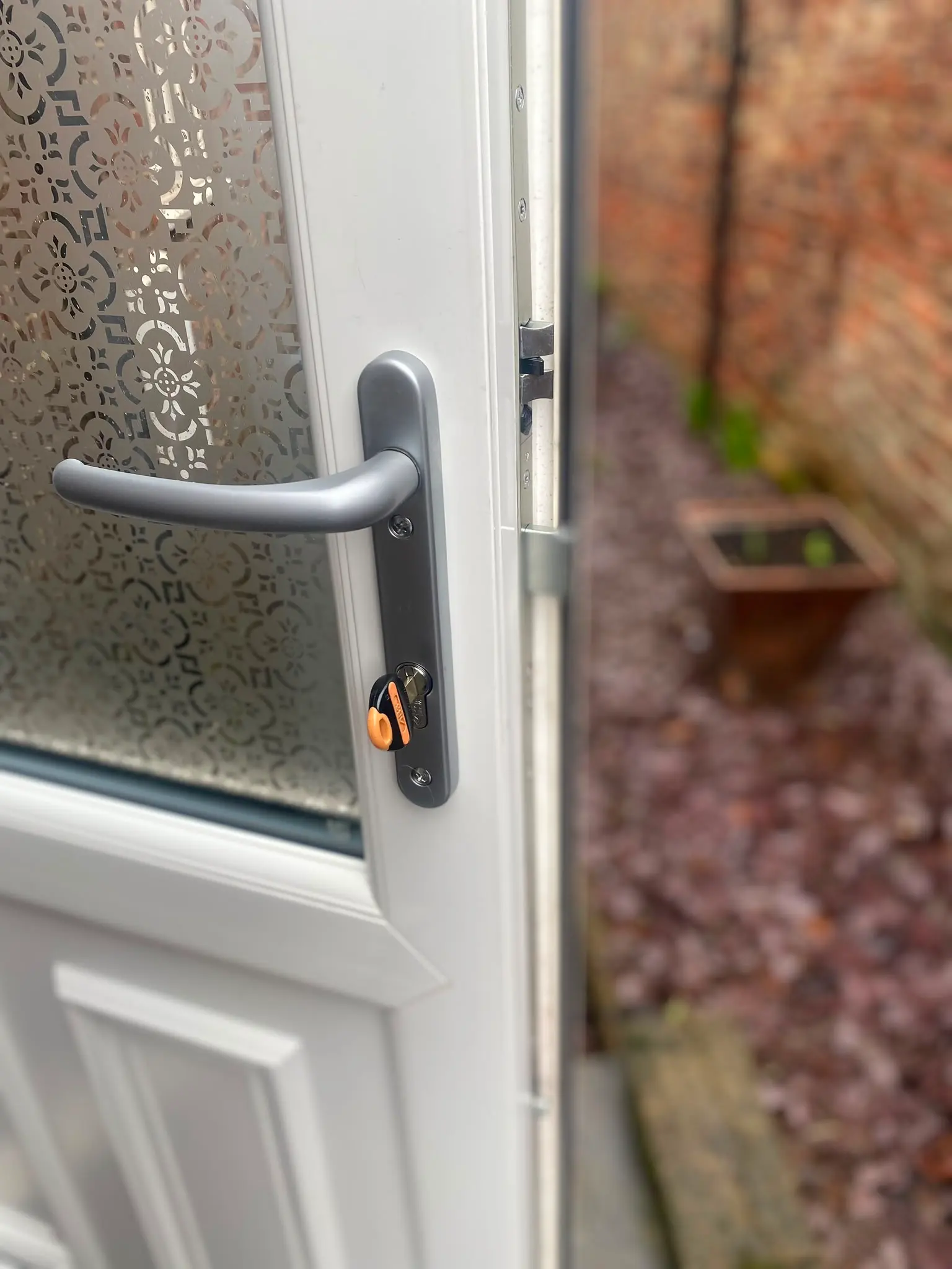 Newly installed high-security anti-snap euro cylinder lock on a white residential uPVC door