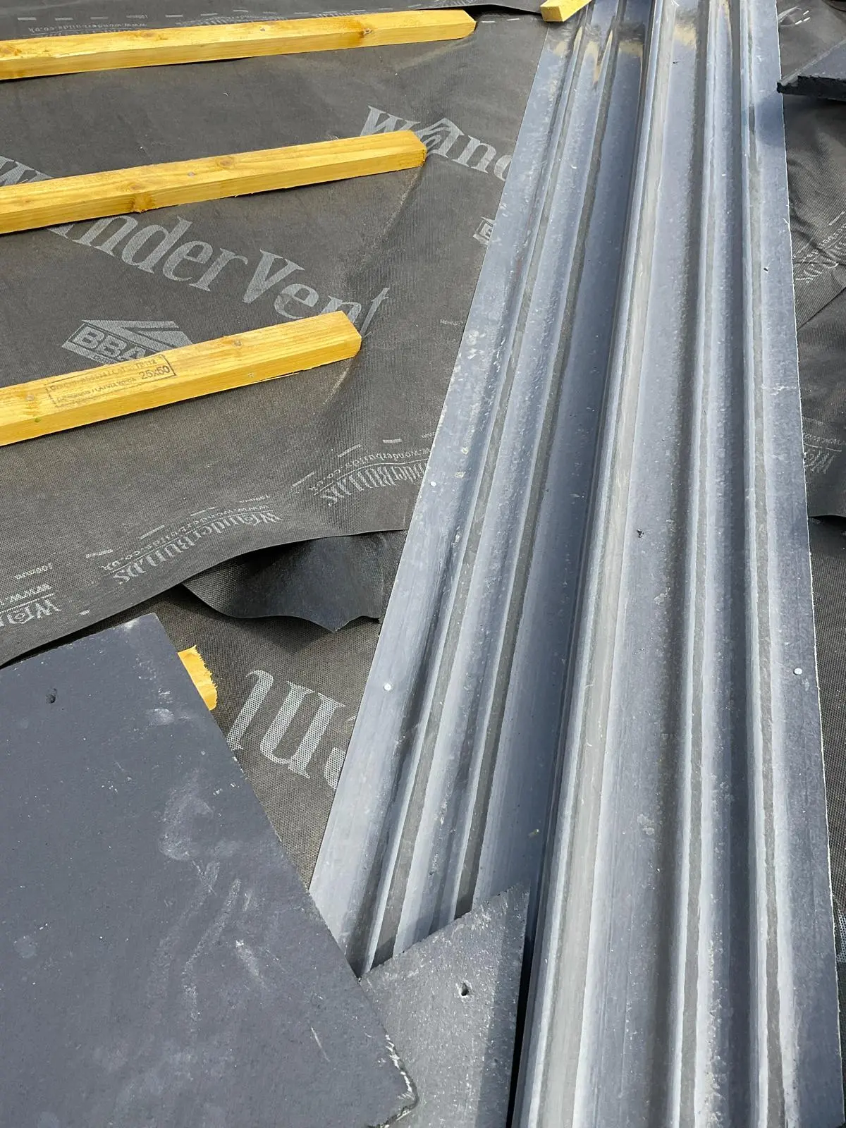 GRP valley trough and slate roof tiles installed on a pitched roof with breathable membrane and timber battens