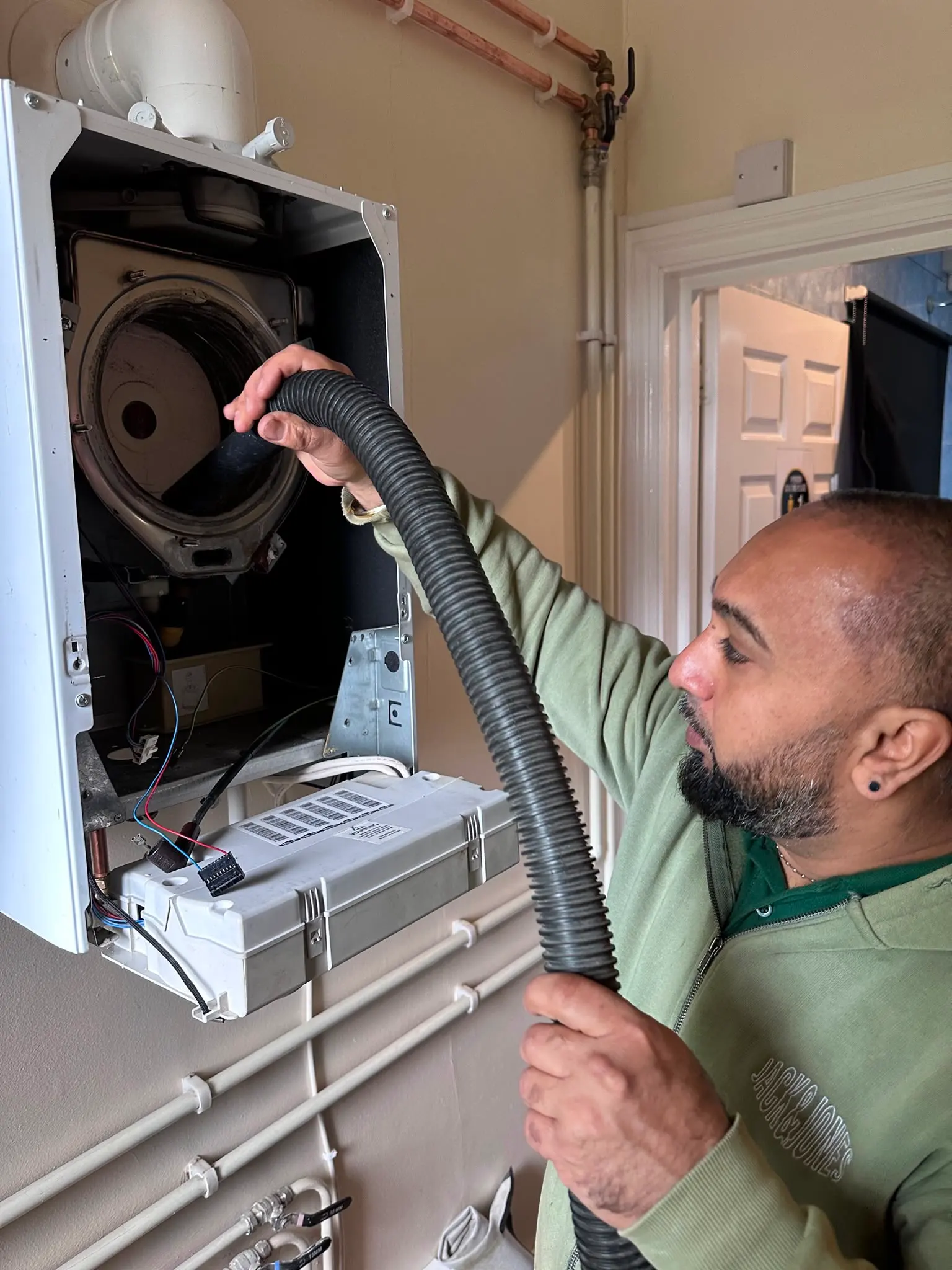 Gas Safe heating engineer servicing a combi boiler