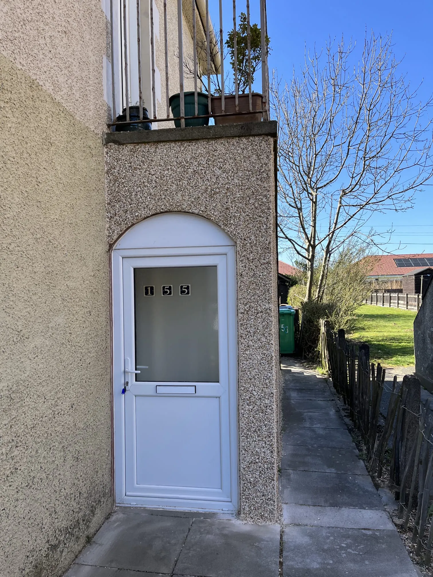 Arched residential entrance porch with traditional roughcast rendering in Fife