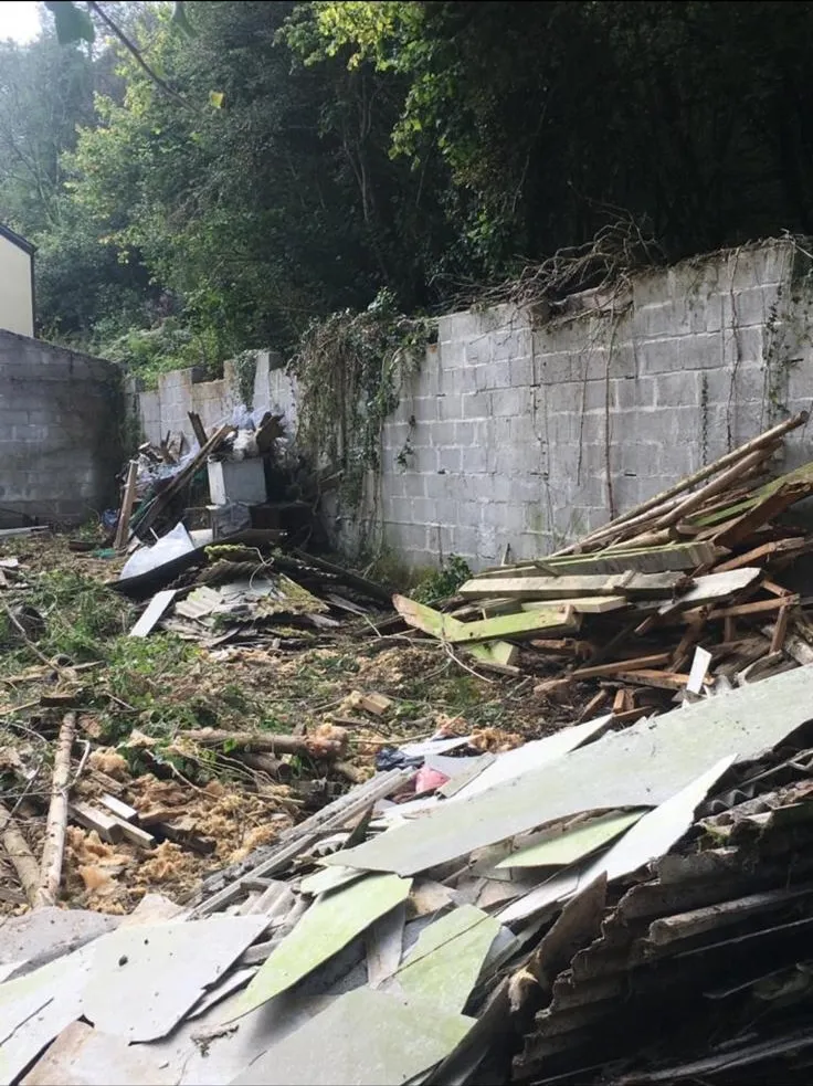 Broken asbestos cement roofing sheets and demolition waste on a site cleared by Stay Safe Environmental.