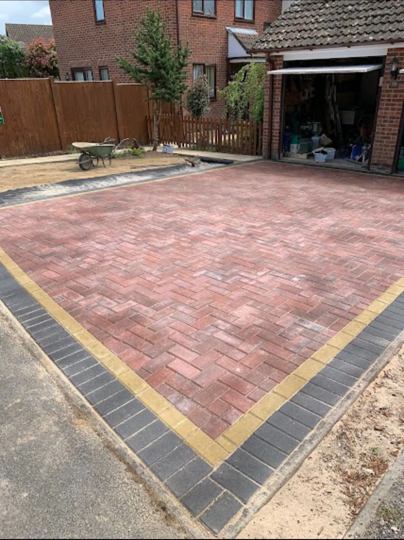Newly installed block paving driveway with decorative borders in front of a house
