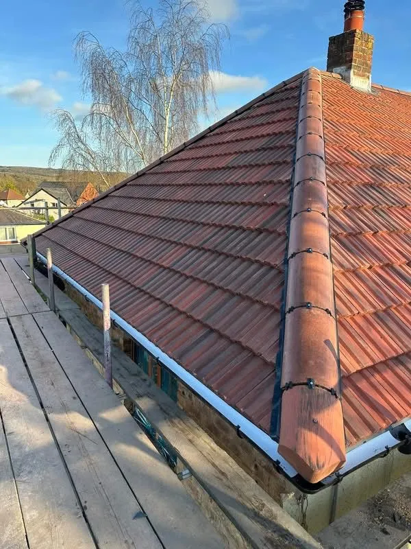 Close-up of a tiled pitched roof with a dry ridge system and scaffolding by Renovation Roofing Ltd.