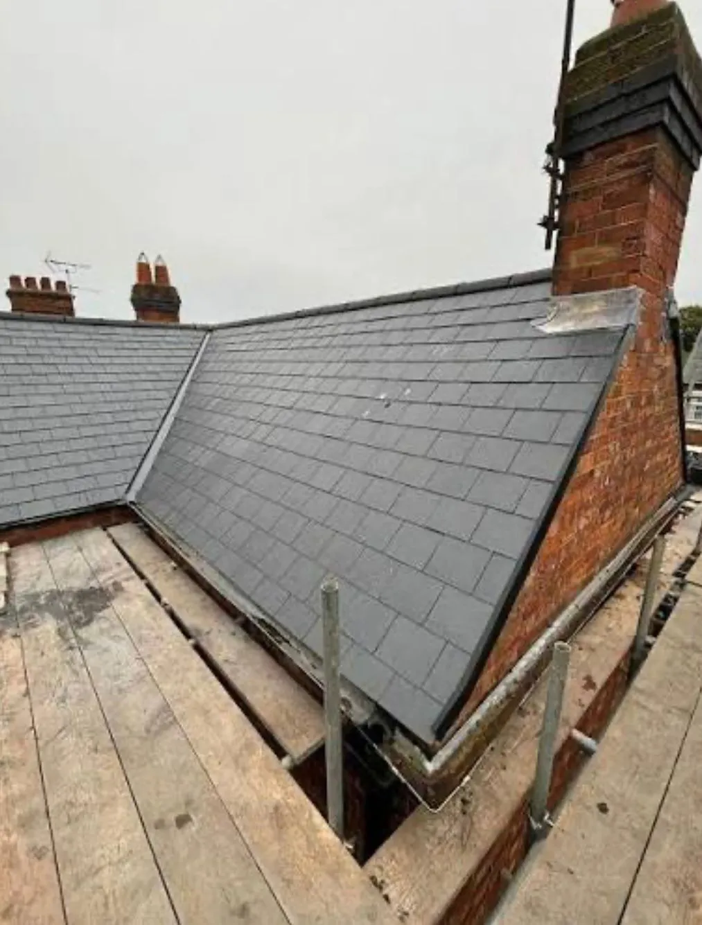 Professional slate roof installation on a brick house in Devon and Cornwall