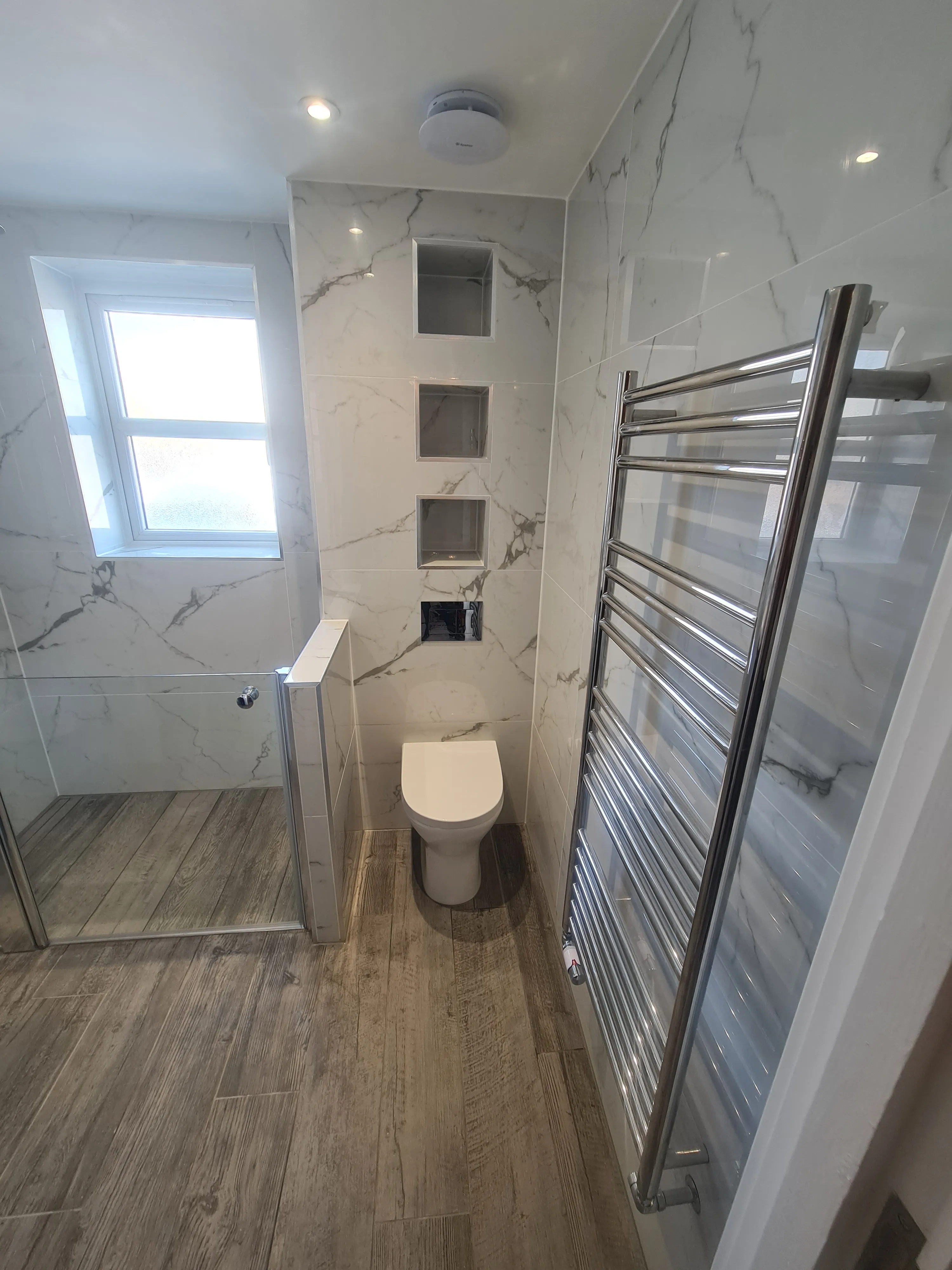 Luxury bespoke bathroom installation in Plymouth featuring marble tiles and a walk-in shower by Sands & Vossen.